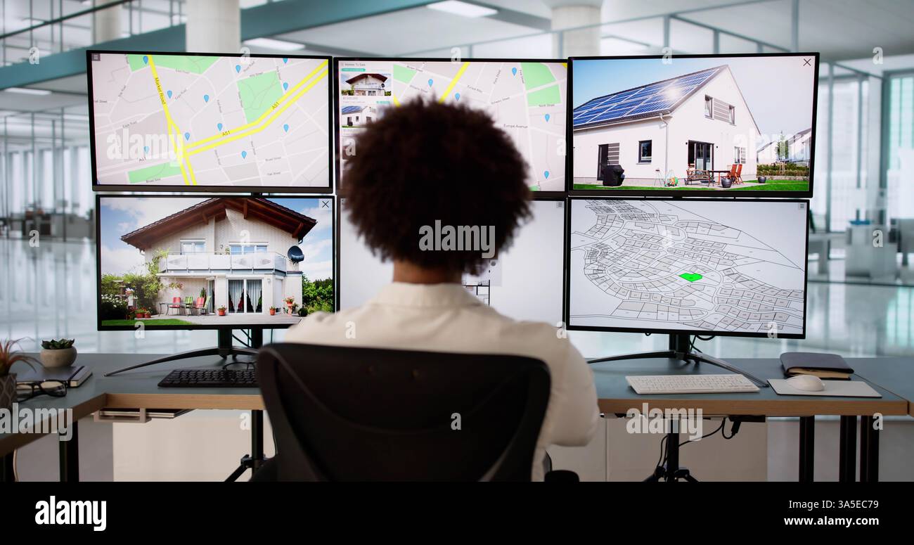 Giovane agente immobiliare maschile che usa il computer per analizzare la proprietà. Foto Stock