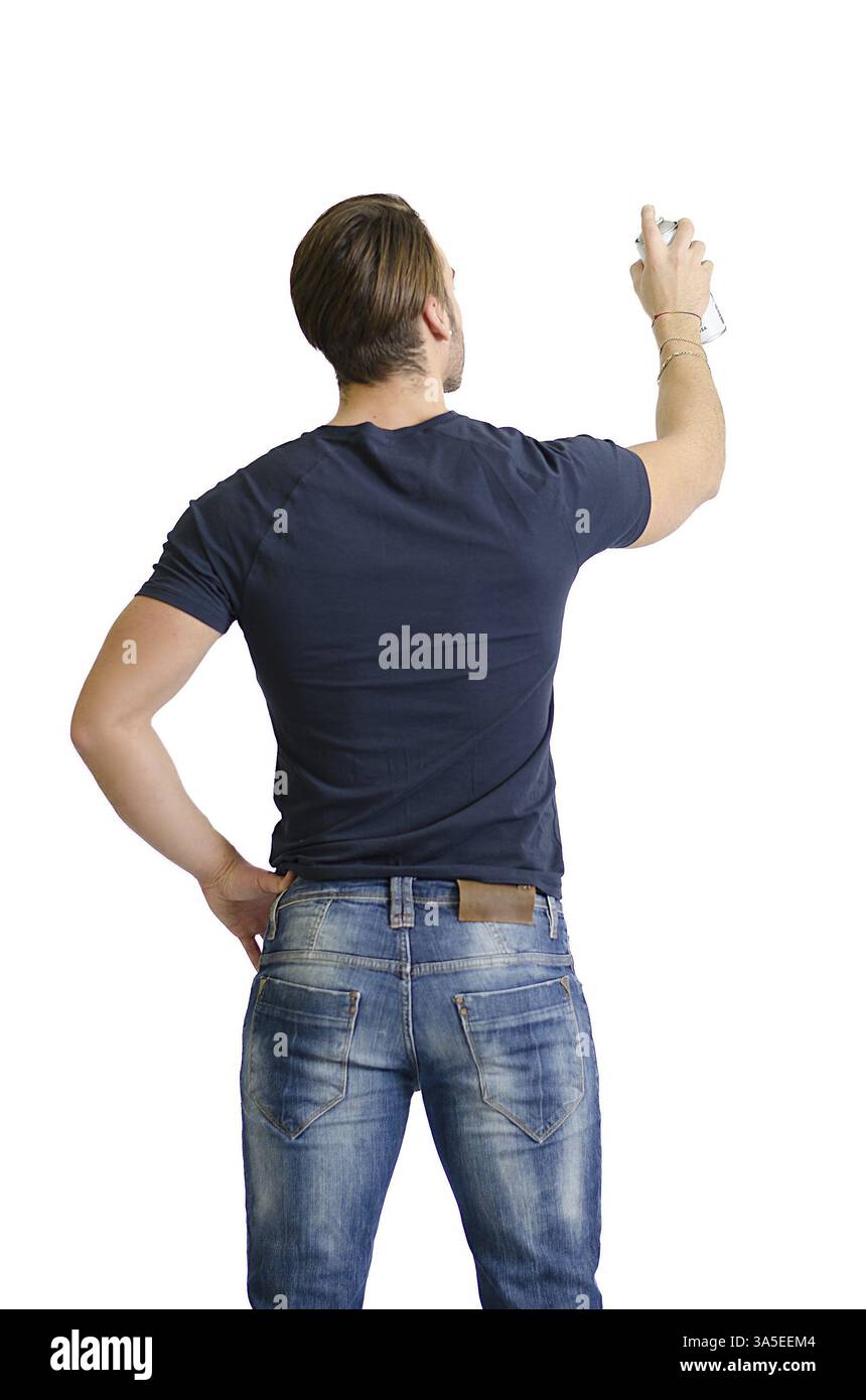 Retro di un giovane con vernice spray disegnare o scrivere su uno spazio vuoto visto da dietro Foto Stock