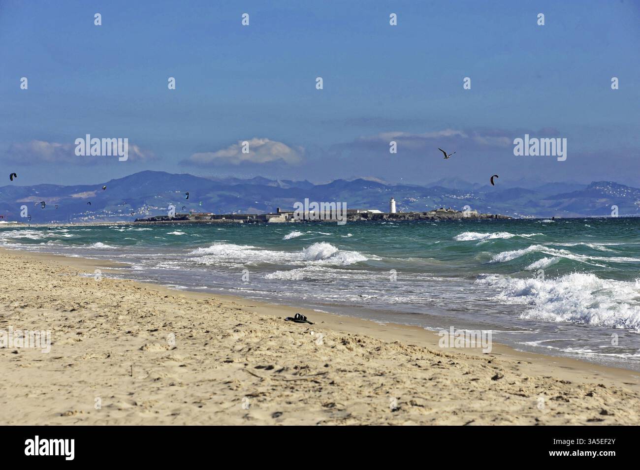 Spiaggia di surf a Baelo Claudio, tra Cadice e Tarifa, Andalusia, Spagna, Europa, pittoresca spiaggia con onde e un faro sullo sfondo, T Foto Stock