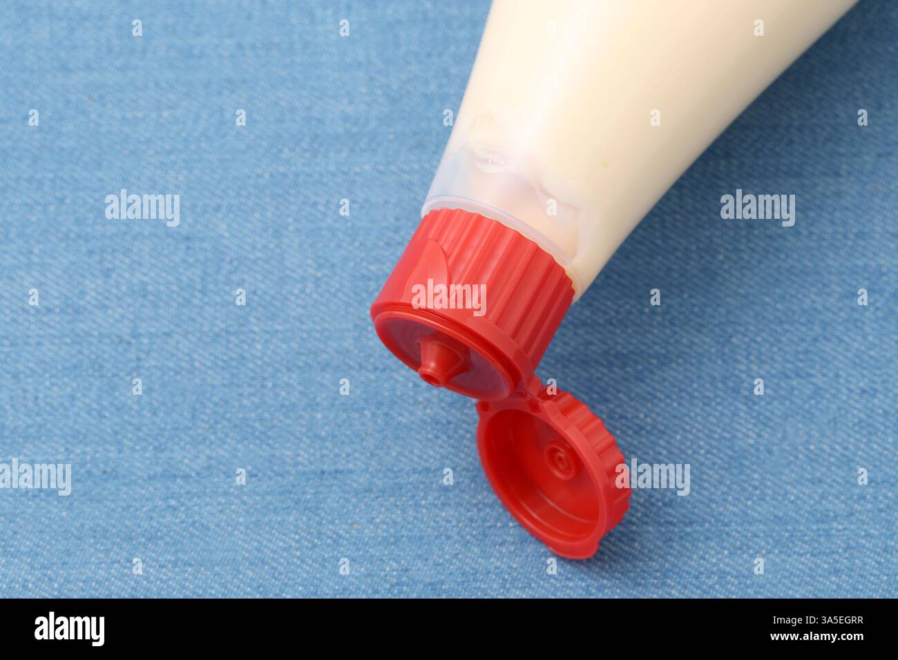 primo piano del flacone di maionese in plastica sullo sfondo del tavolo Foto Stock
