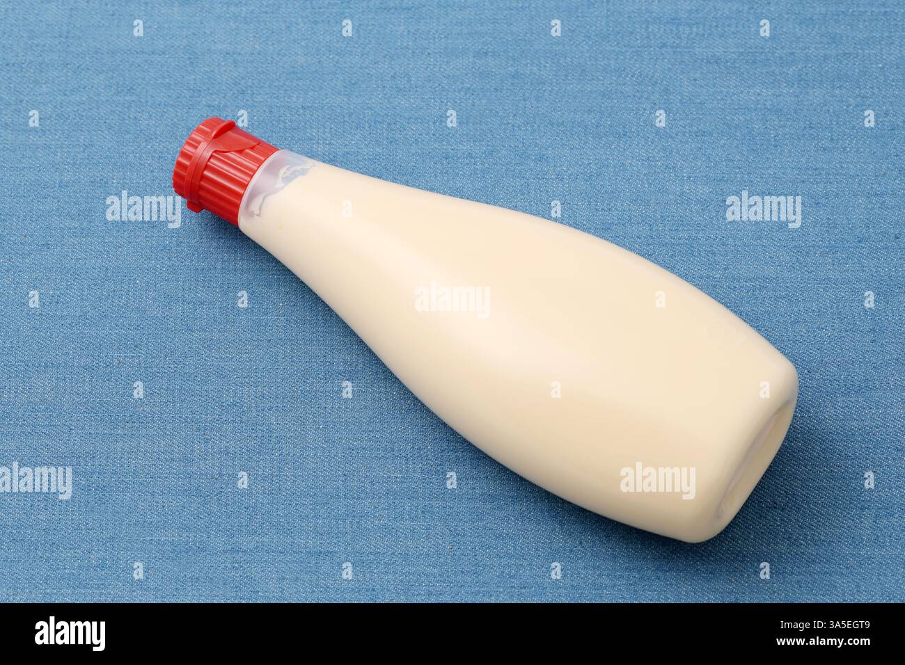 primo piano del flacone di maionese in plastica sullo sfondo del tavolo Foto Stock