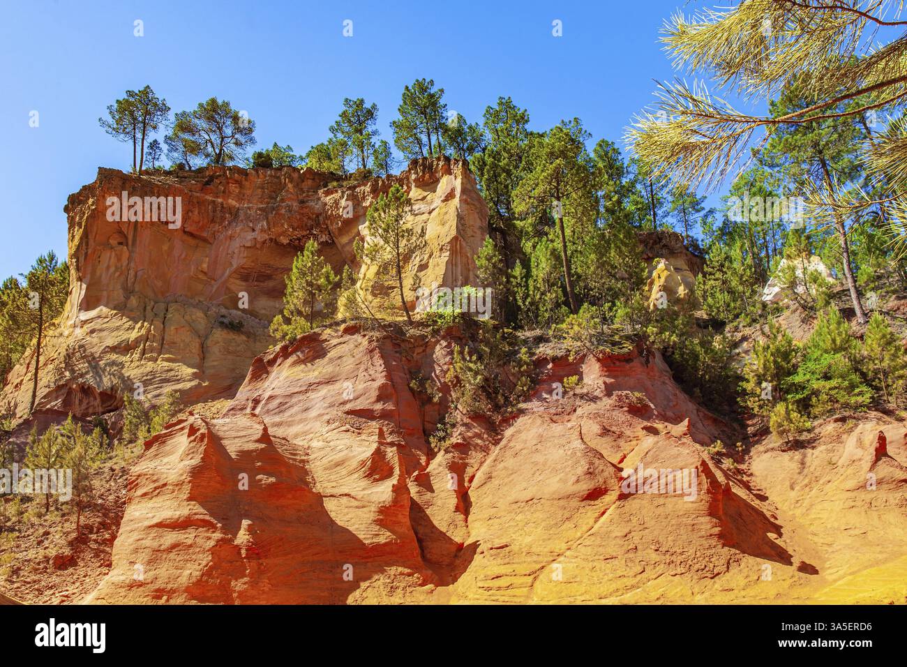Provenza, Francia. Rocce bizzarre e dai colori vivaci illuminate dal sole di mezzogiorno. Passeggia lungo il più bel percorso rosso-giallo-arancione. Le rocce sono coperte Foto Stock
