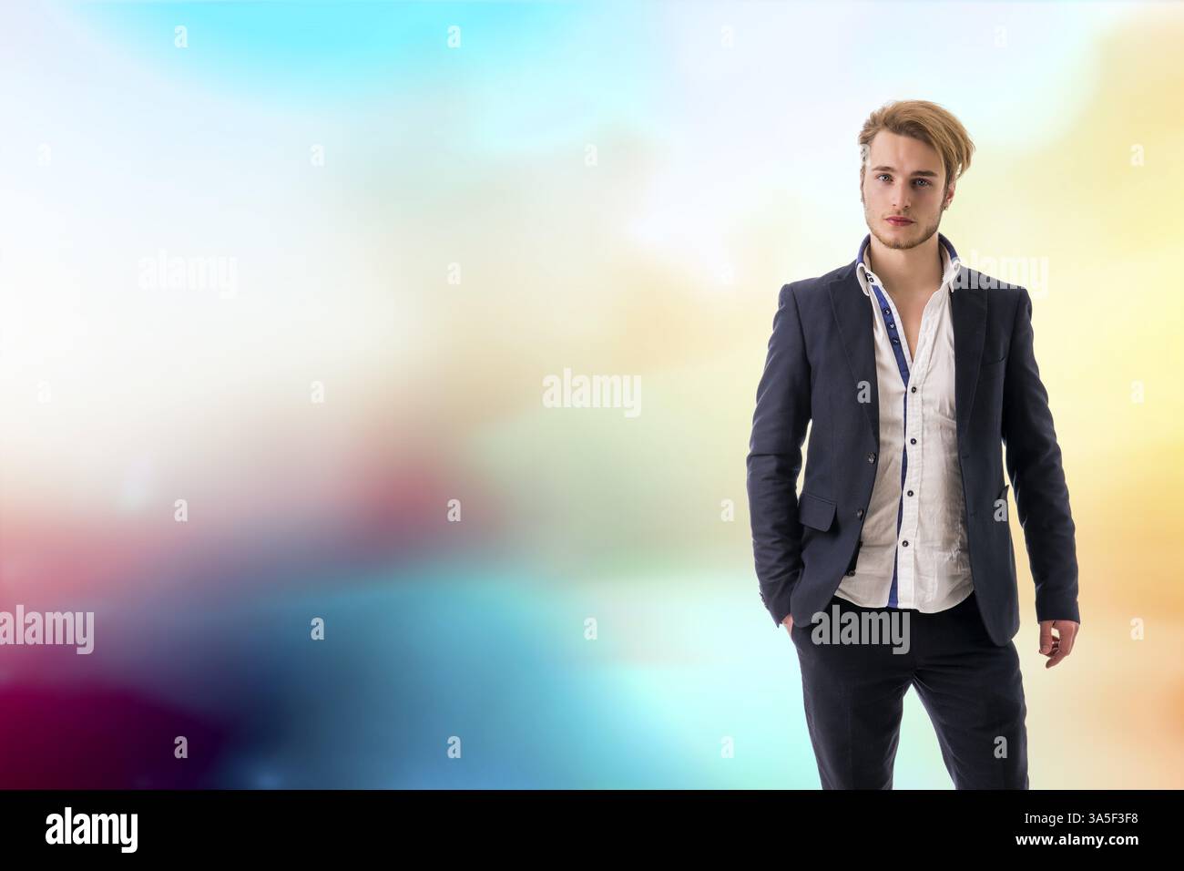 Ritratto di bella bionda giovane uomo, occhi blu, su colorato sfondo astratto Foto Stock