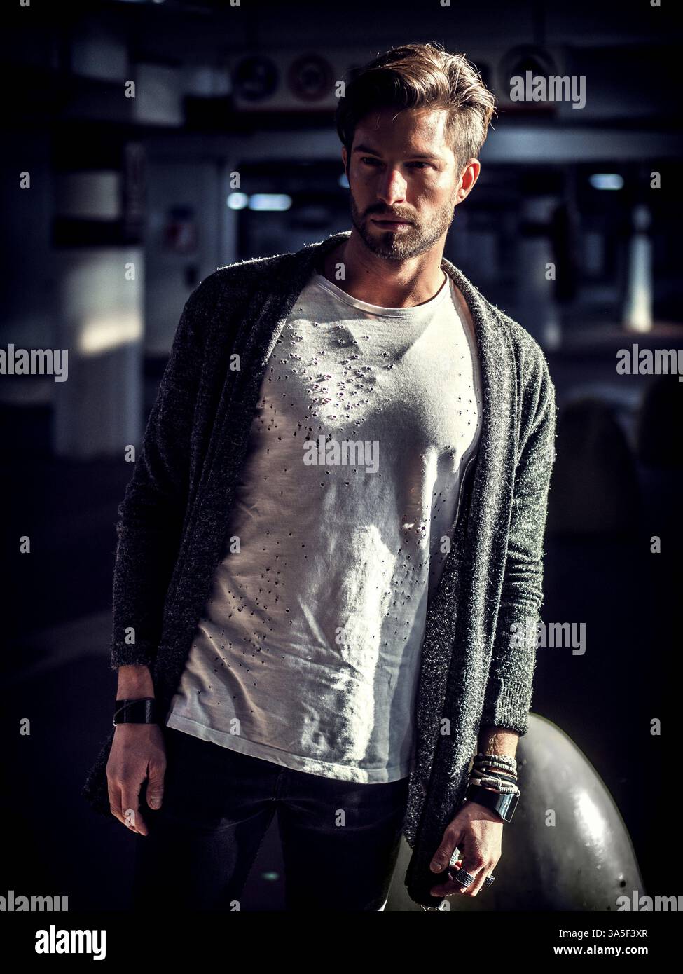 Bell'uomo muscoloso in abbigliamento casual sullo sfondo del parcheggio Foto Stock