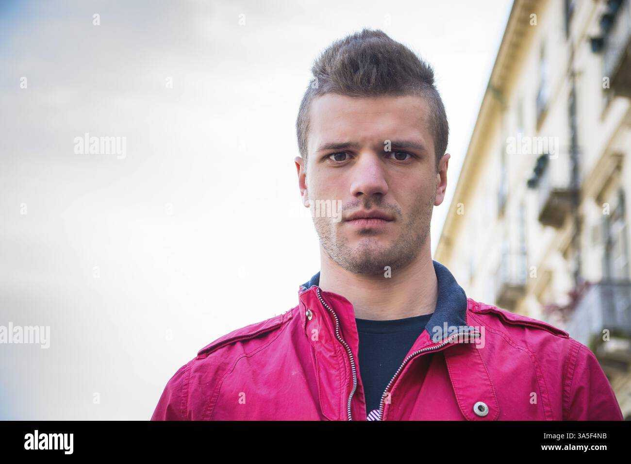 Colpo di Testa del bel giovane in strada di città, guardando la fotocamera Foto Stock