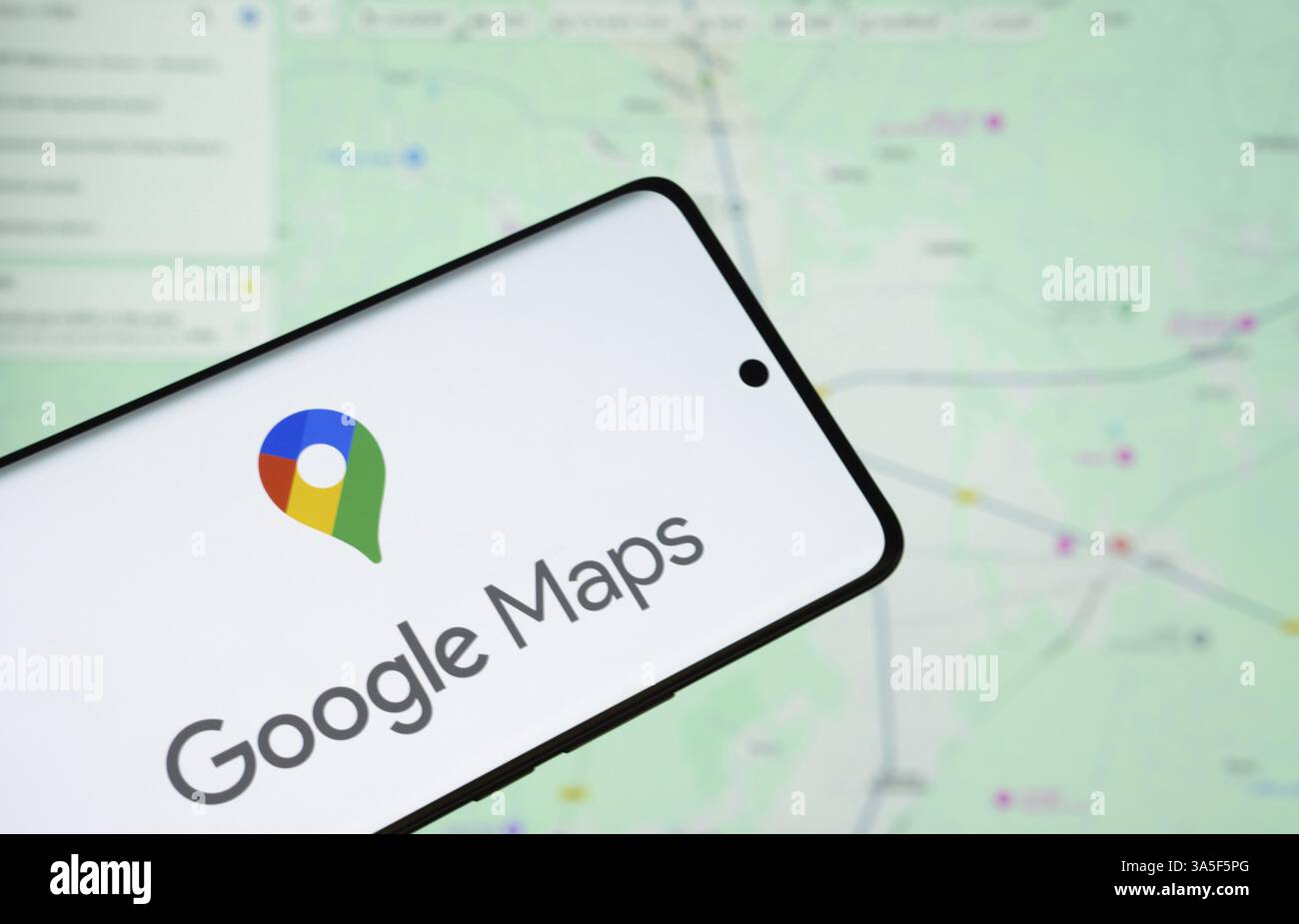 Il logo di google Maps viene visualizzato sullo schermo di uno smartphone e il sito Web google Maps è visibile sullo schermo di un computer sullo sfondo Foto Stock