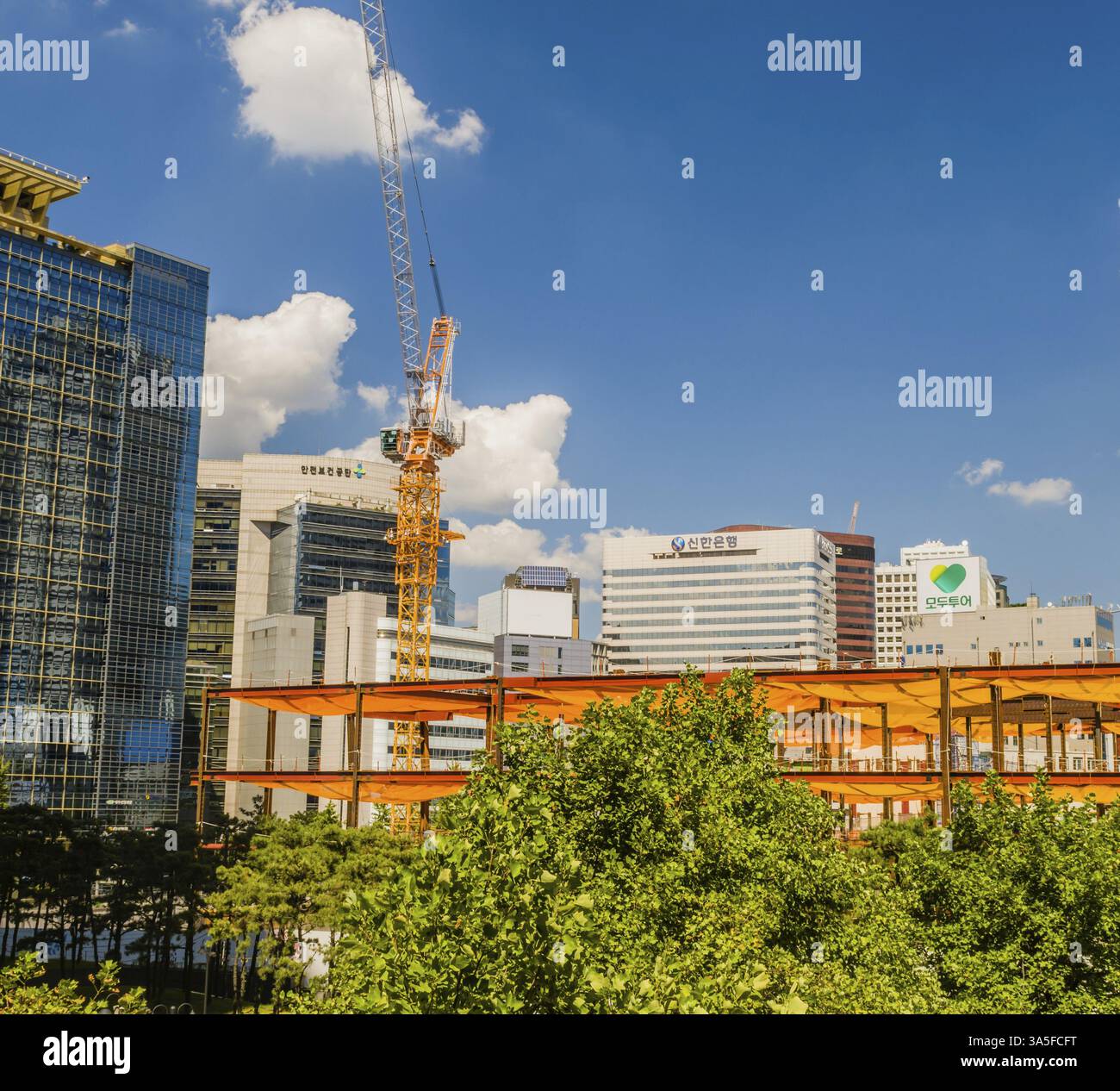 Seoul, Corea del Sud, 9 settembre 2018: Imponente gru da costruzione gialla nel centro città tra alti edifici di uffici con braccio a braccio lungo esteso fino a BL Foto Stock