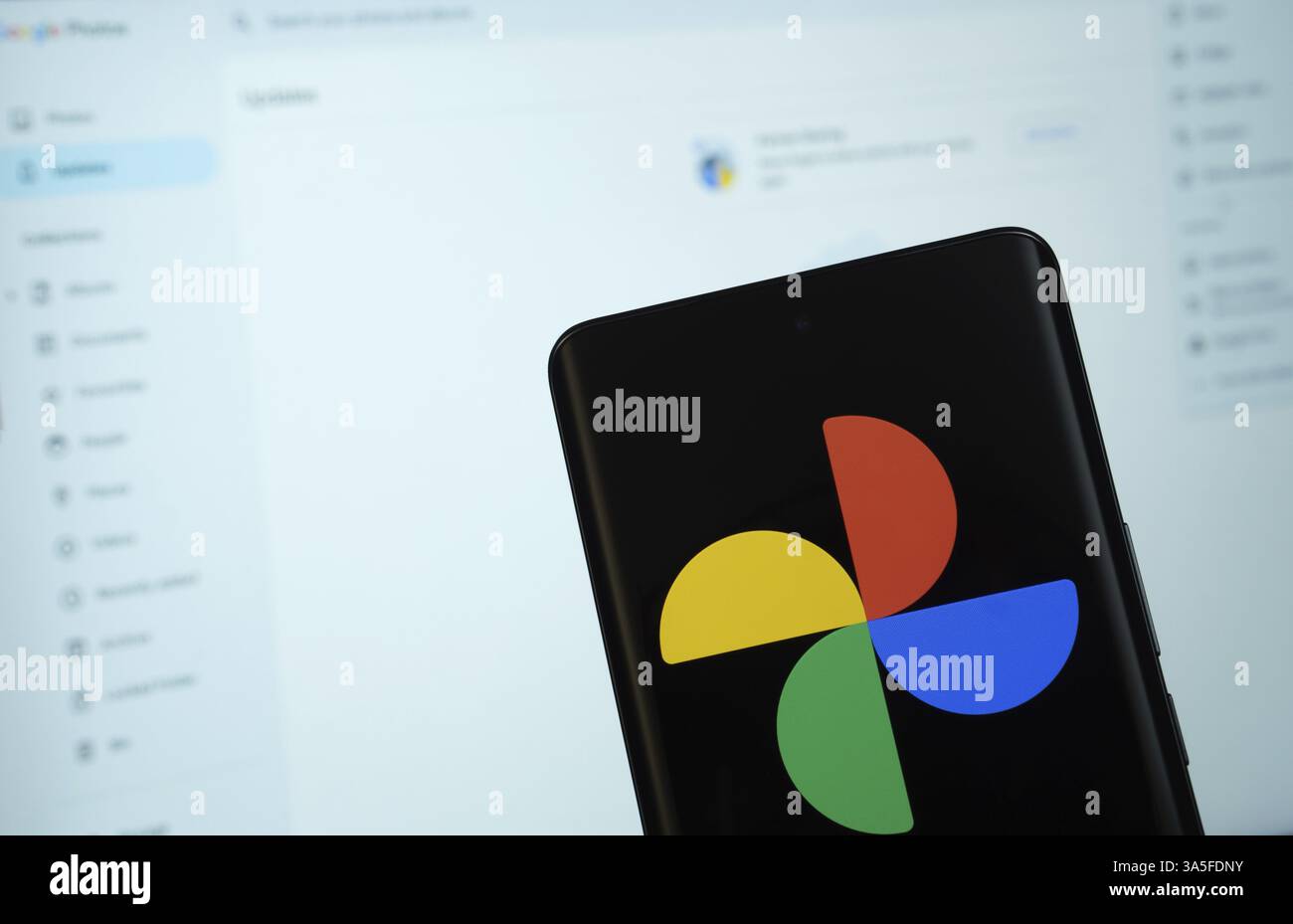 Il logo di google foto viene visualizzato sullo schermo di uno smartphone e il sito Web google foto è visibile sullo schermo di un computer sullo sfondo Foto Stock