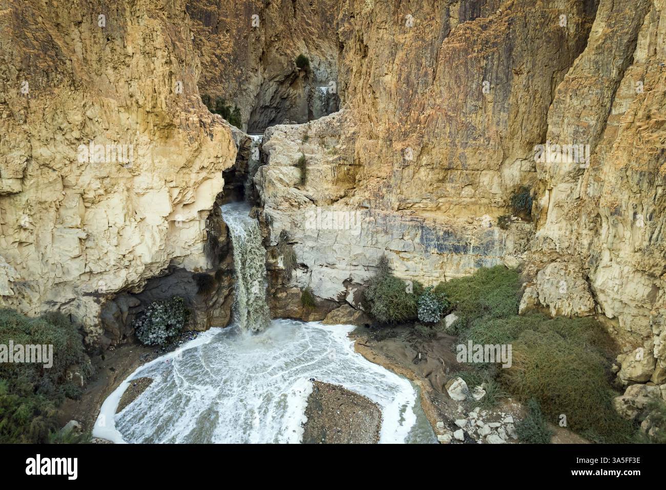 Potente cascata nel deserto della Giudea intorno al Mar morto dopo pesanti piogge invernali. Israele. Immagine astratta di un evento reale. Angolo imprevisto originale Foto Stock