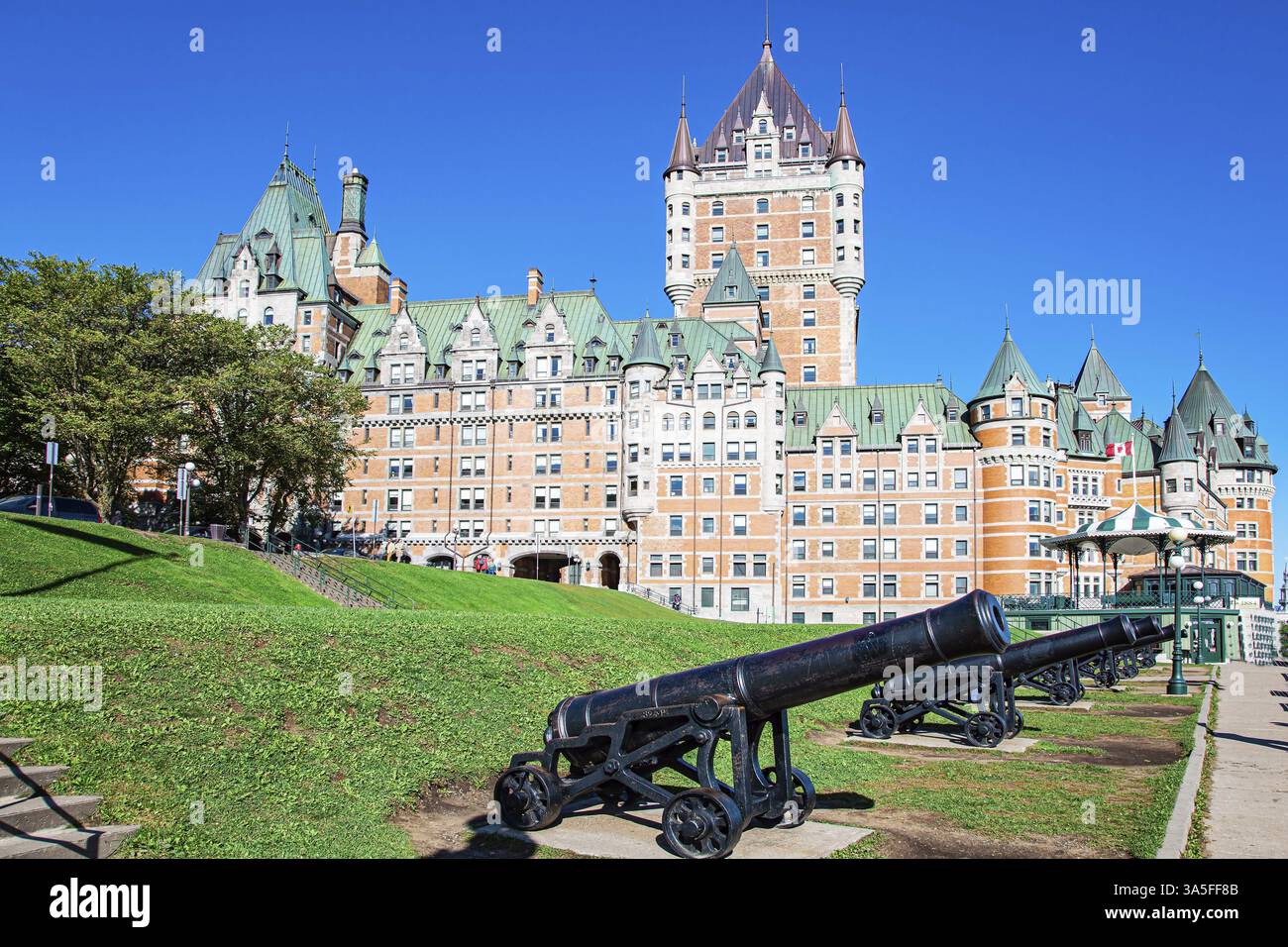 Cannoni antichi in ghisa sul lungomare del Quebec. Splendido edificio architettonico del Québec: L'hotel Chateau Frontenac, il più fotografato Foto Stock