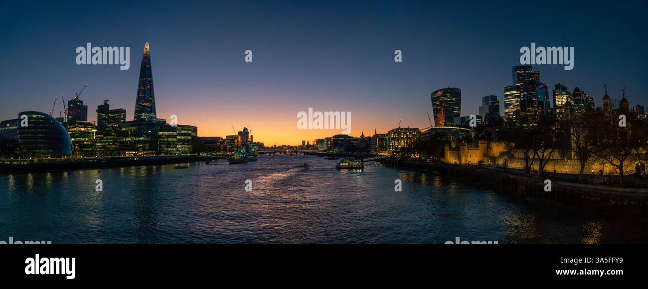 Vista panoramica dello skyline di Londra lungo il Tamigi al tramonto, con il grattacielo illuminato dello Shard e il distretto finanziario della City. Foto Stock