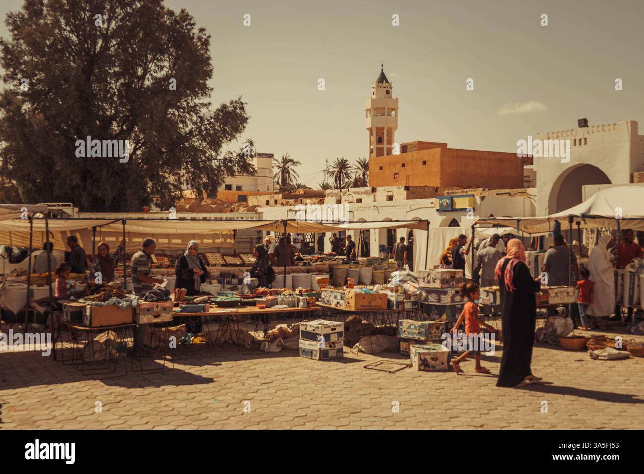 Un vivace mercato di Douz in Tunisia con venditori ambulanti, merci colorate e architettura tradizionale Foto Stock