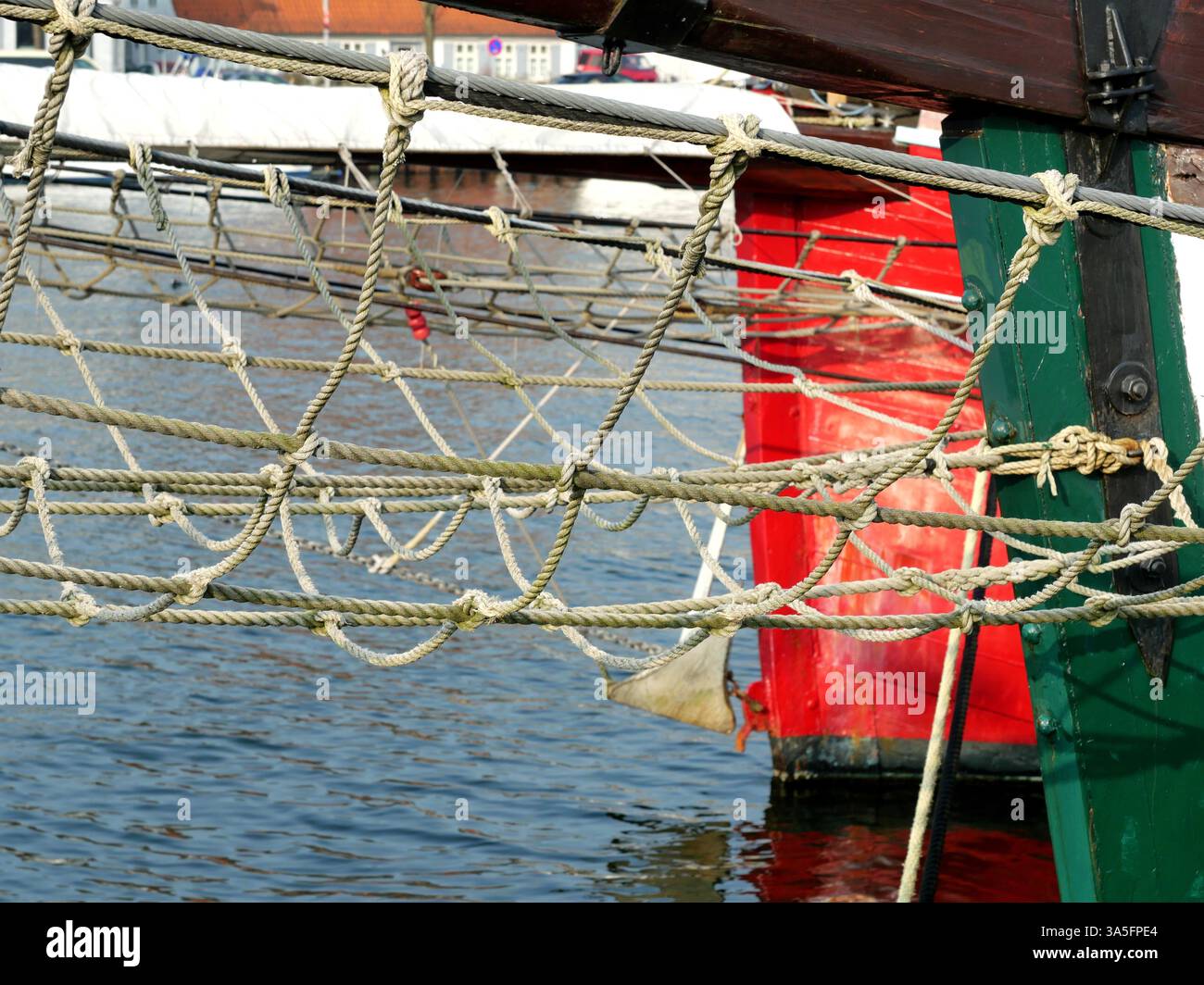 La rete di sicurezza sulla prua di una nave a vela protegge l’equipaggio in mari difficili. Un motivo marittimo a maglia grossa che simboleggia sia la sicurezza che la tradizione marinara Foto Stock