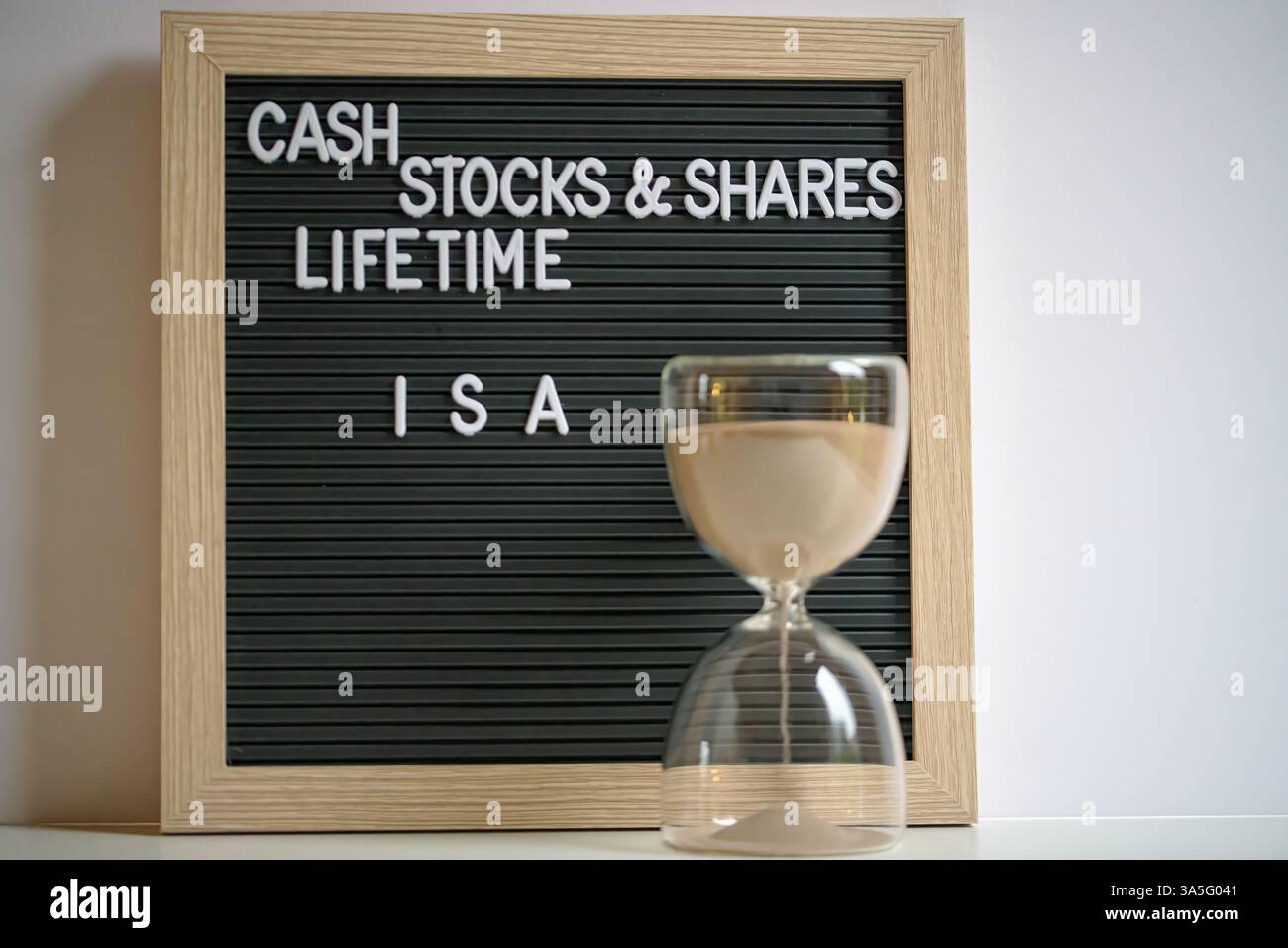 Una struttura in legno con lettere Cash Stock e condivide gli ISA a vita con un'ora di tempo e un investimento Foto Stock