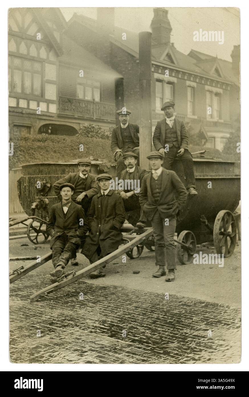 Cartolina originale dei primi anni '1900 di lavoratori stradali, muratura stradale / gruppo di lavoro, utilizzando carri portatili trainati da cavalli a vapore contenenti catrame. Potrebbero essere dei blocchi stradali in legno, noti come pavimentazione Nicolson / Nicholson - usati come alternativa ai ciottoli, per la loro superficie più silenziosa e liscia, e per la sicurezza degli zoccoli dei cavalli. Si ritiene che questa strada si trovi nella Small Heath area di Birmingham, Inghilterra, nel Regno Unito intorno al 1912 Foto Stock