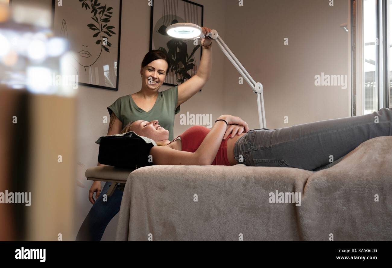 Primo piano di bellezza di una giovane donna che si solleva la ciglia con un sollevamento ciglia da parte di un estetista in un salone di bellezza. Dare forma alle sopracciglia. Foto Stock