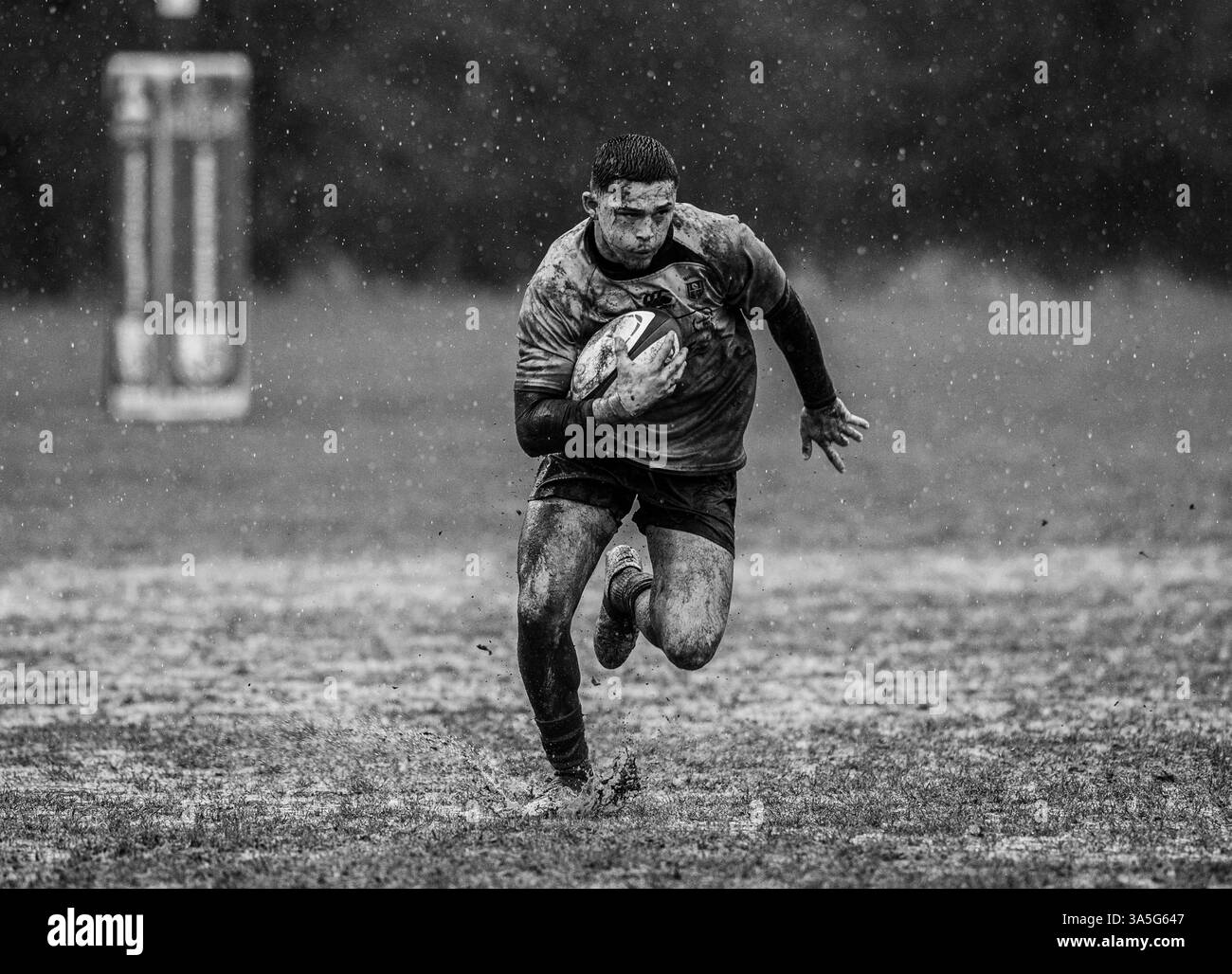 Partita amatoriale di rugby Union maschile giocata in condizioni di pioggia e fangoso. Foto Stock
