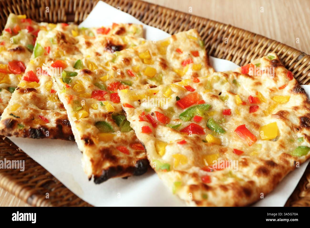 Fette di delizioso Chili Naan in un cestino di vimini Foto Stock