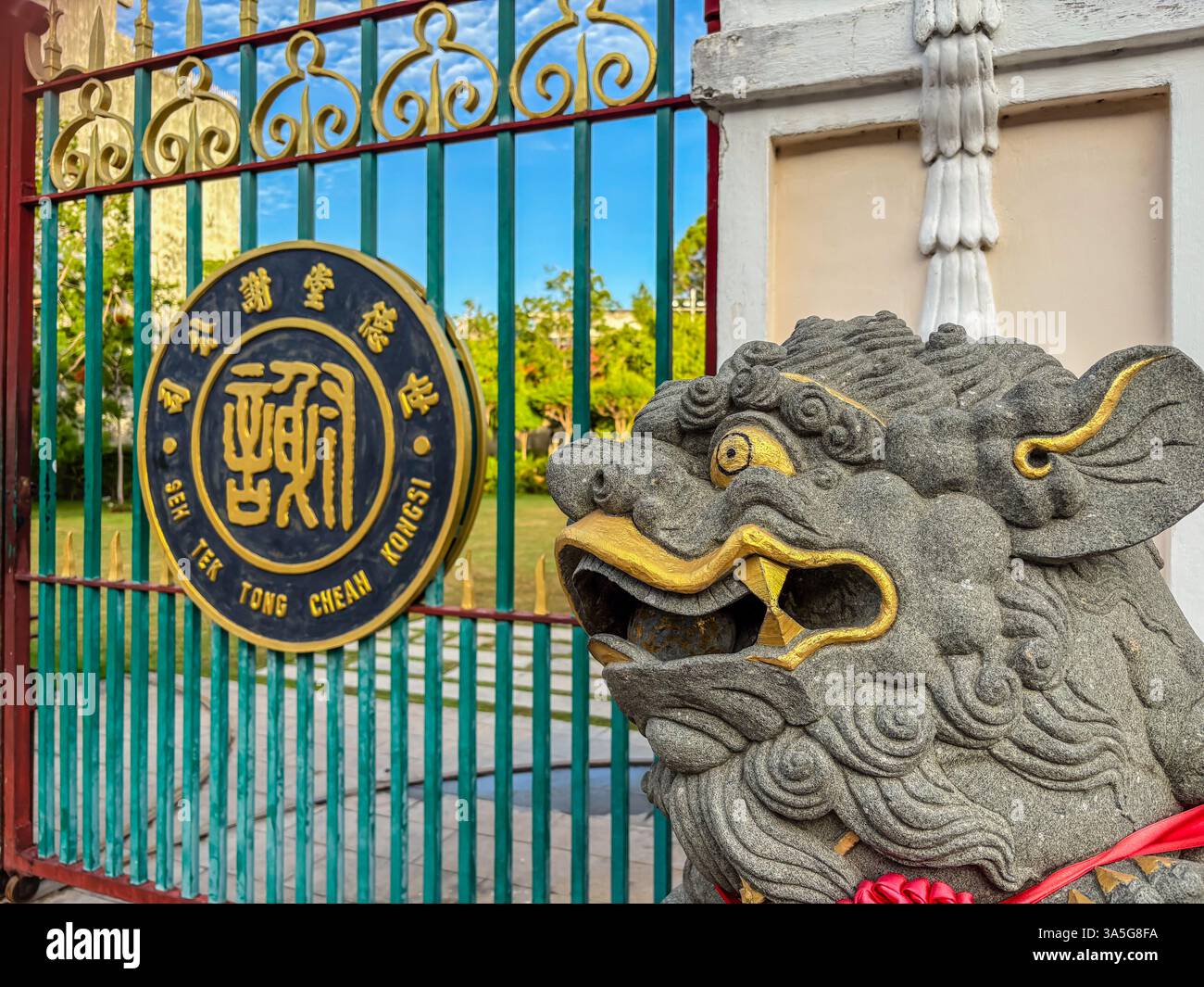 Primo piano del cancello di Cheah Kongsi con una statua di leone di pietra, George Town, Penang, Malesia in una giornata di sole. Foto Stock