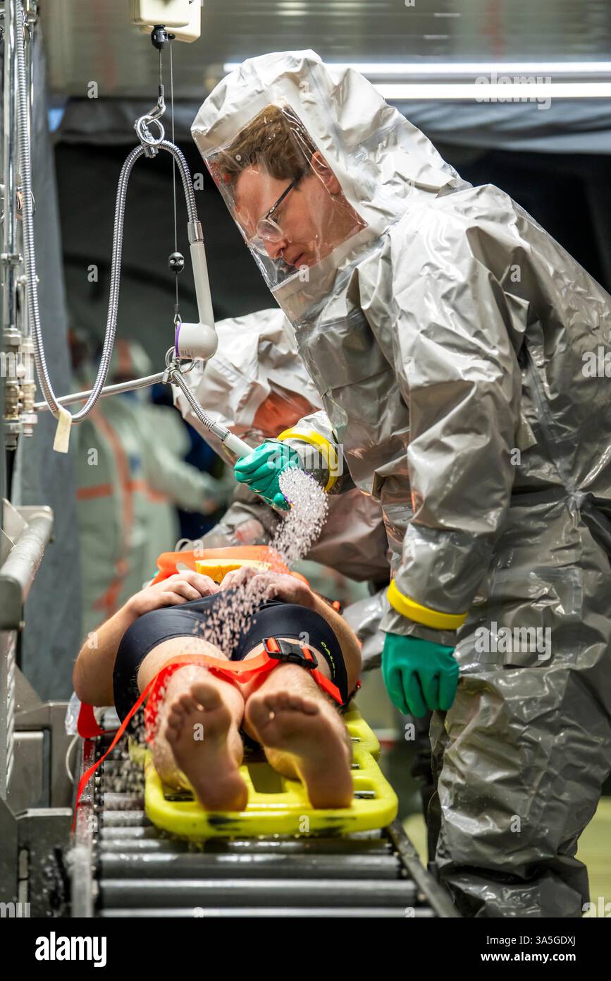 Decontaminazione delle persone ferite dopo un incidente simulato con sostanze pericolose. I vigili del fuoco e le organizzazioni umanitarie esercitano la loro attività Foto Stock