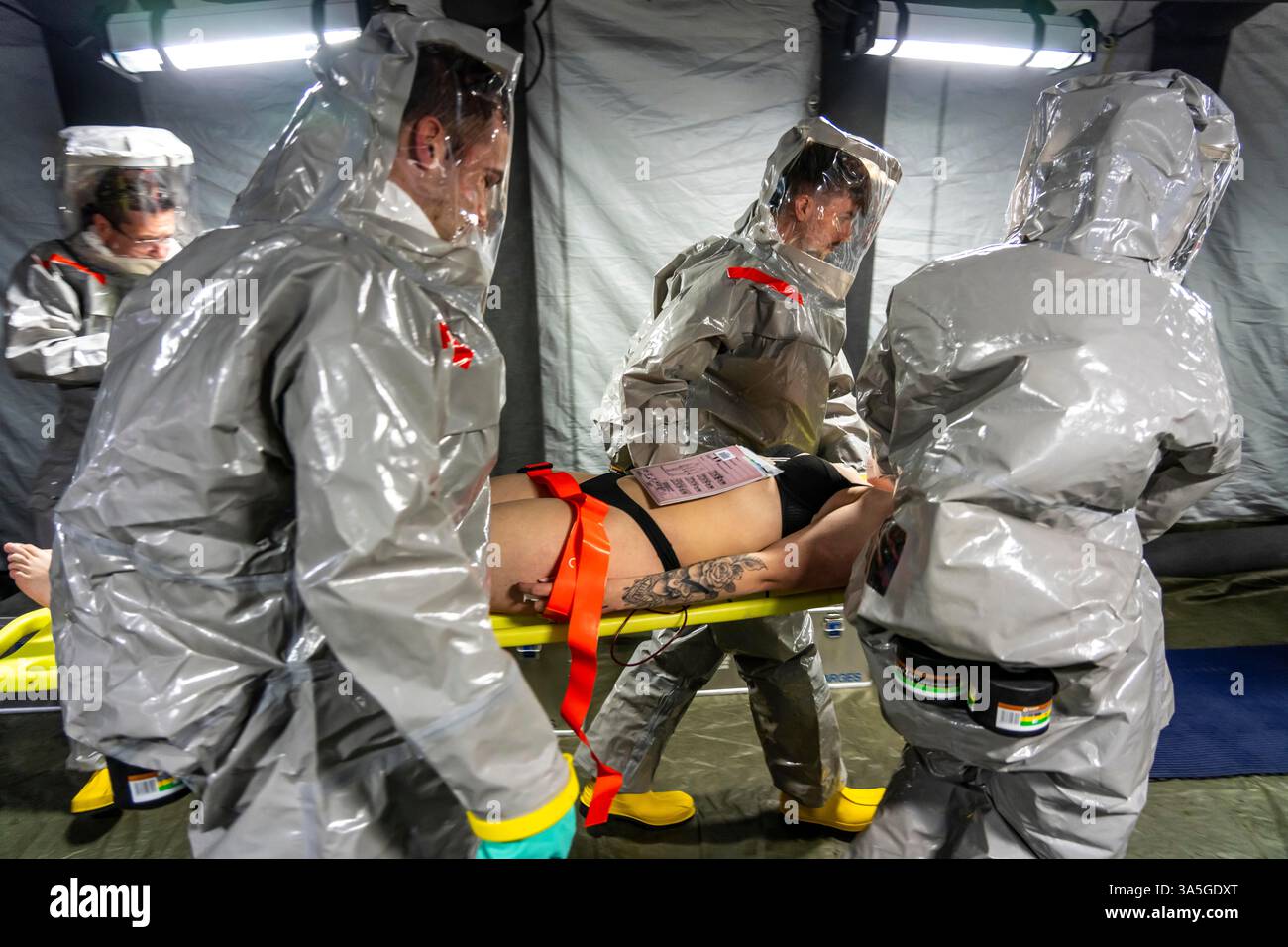 Decontaminazione delle persone ferite dopo un incidente simulato con sostanze pericolose. I vigili del fuoco e le organizzazioni umanitarie esercitano la loro attività Foto Stock