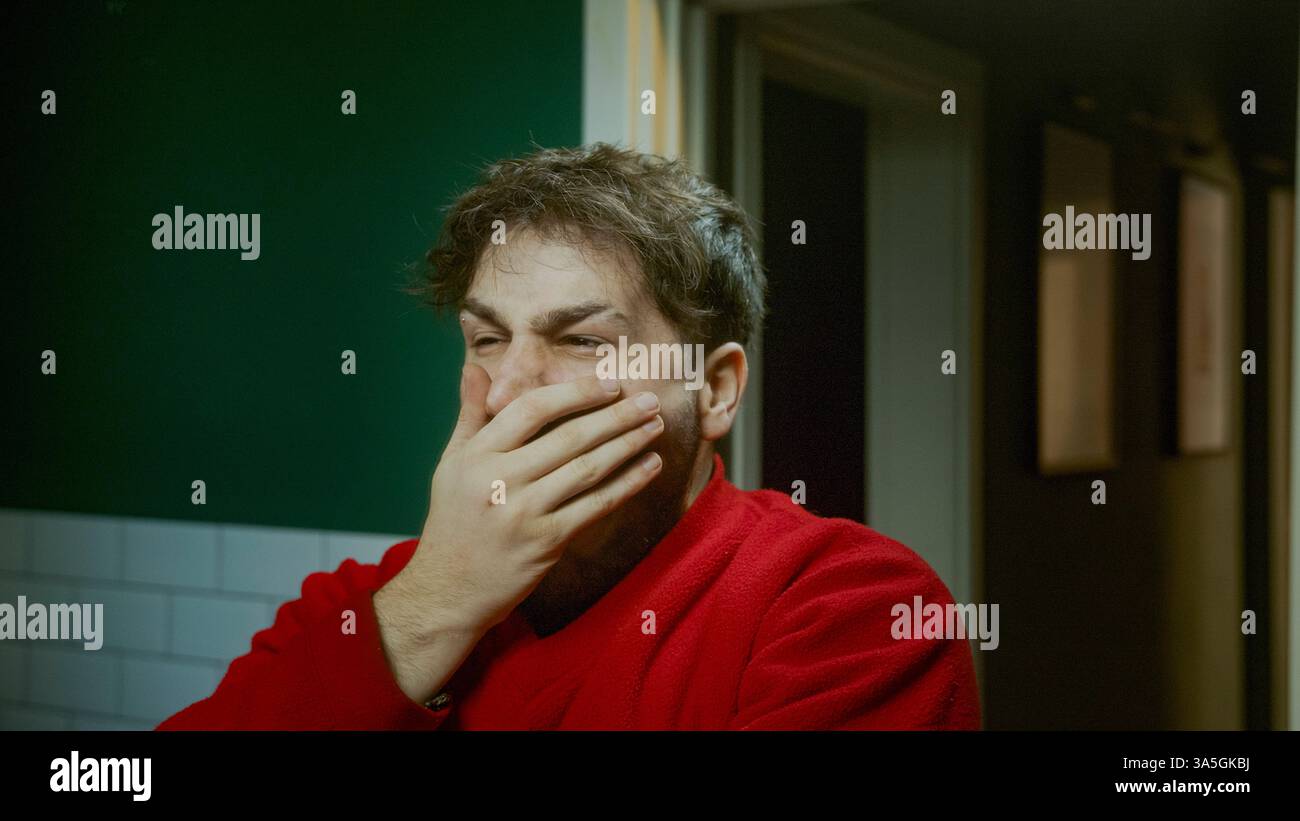 Giovane che sbadiglia la mattina cercando di svegliarsi e sentirsi sonnolento lottando con la stanchezza e la routine mattutina Foto Stock