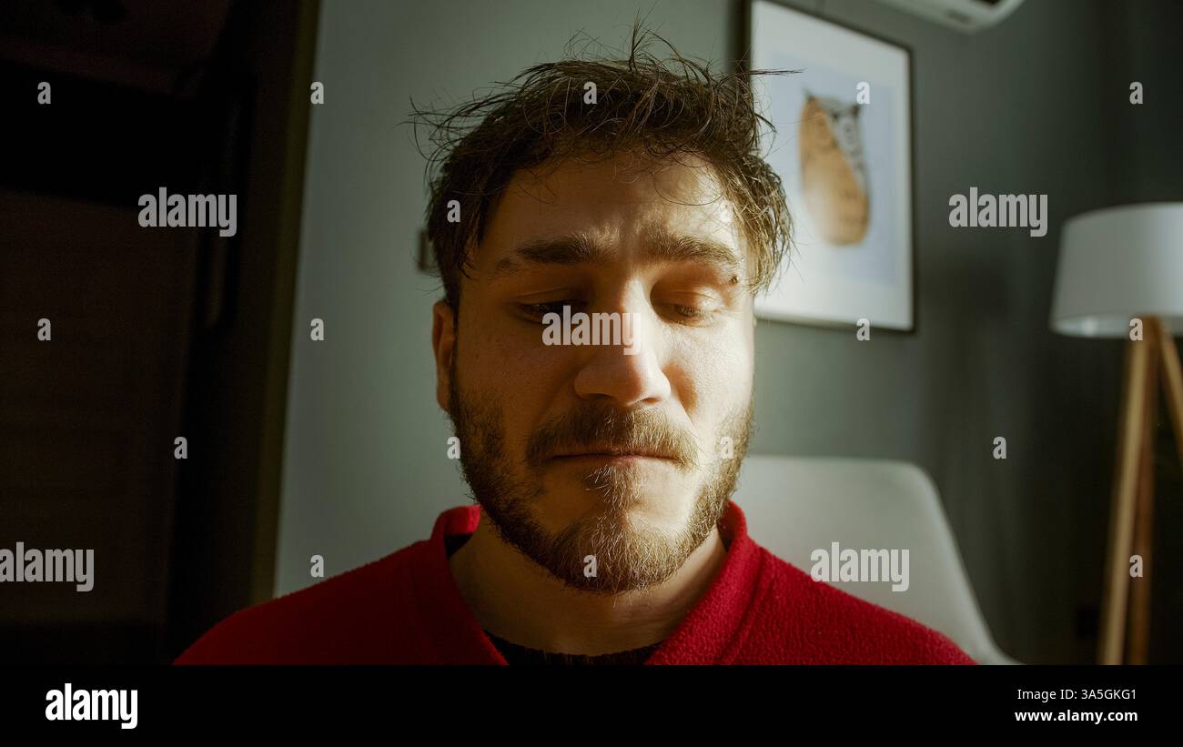 Primo piano emotivo di un uomo in difficoltà che tiene una pistola alla testa in Dramatic Lighting - concetto di disperazione, depressione e lotta interiore Foto Stock