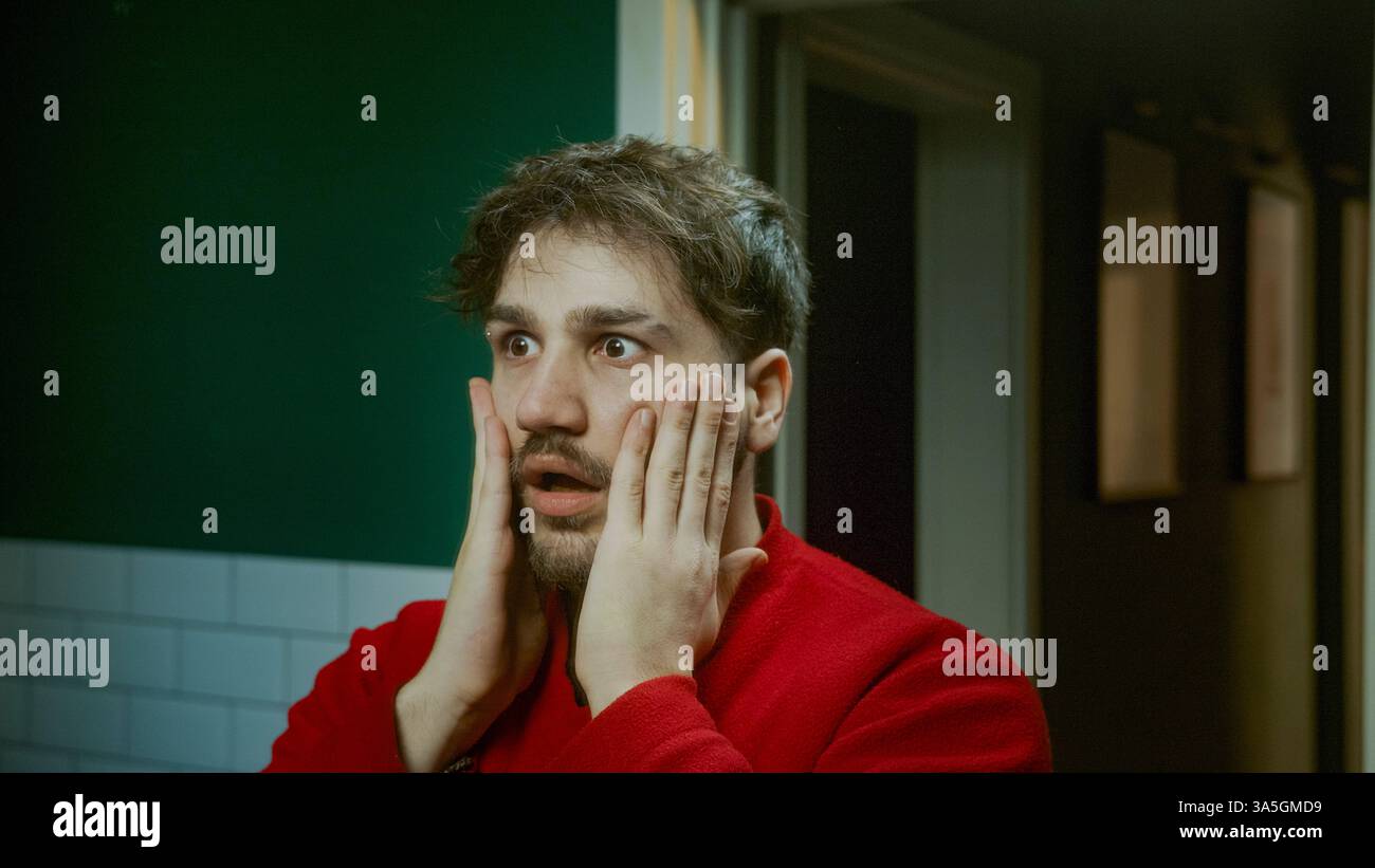 Un giovane assonnato che sbadiglia la mattina cercando di svegliarsi e di sentirsi sonnolento, lottando con la stanchezza e la routine mattutina Foto Stock