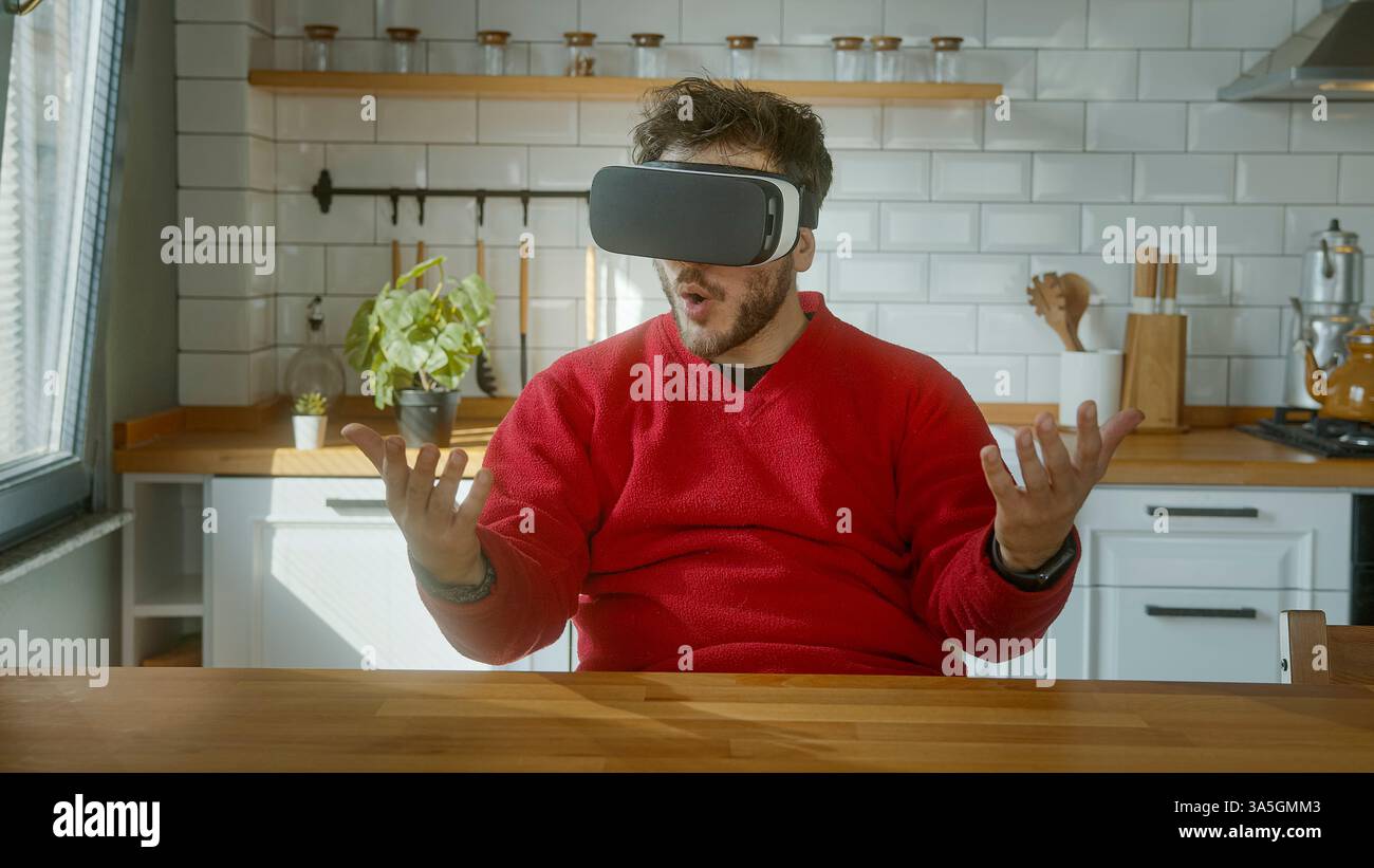 Giovane che prova un'entusiasmante avventura in realtà virtuale con un visore VR, che si allontana con le mani Foto Stock