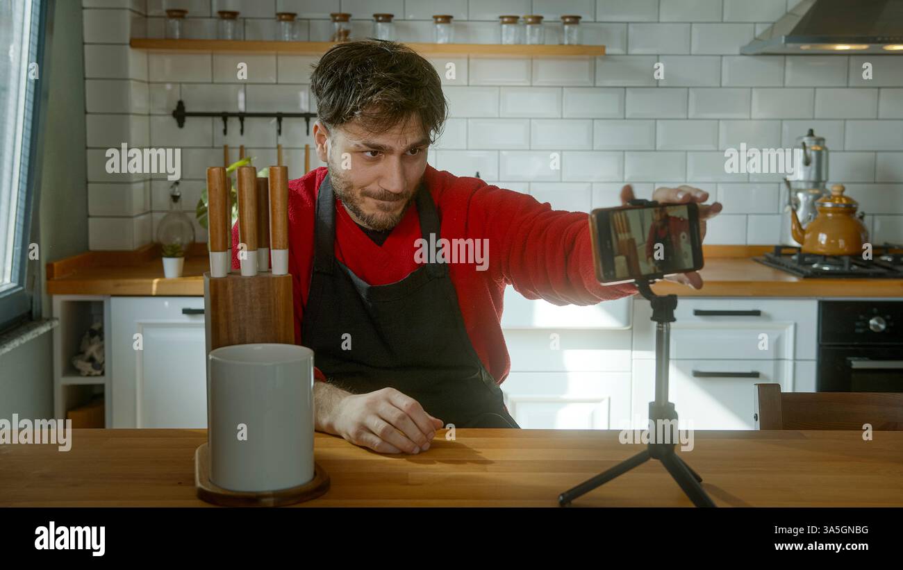 Giovane chef maschile che rivede un coltello da cucina professionale per un tutorial di cucina Foto Stock