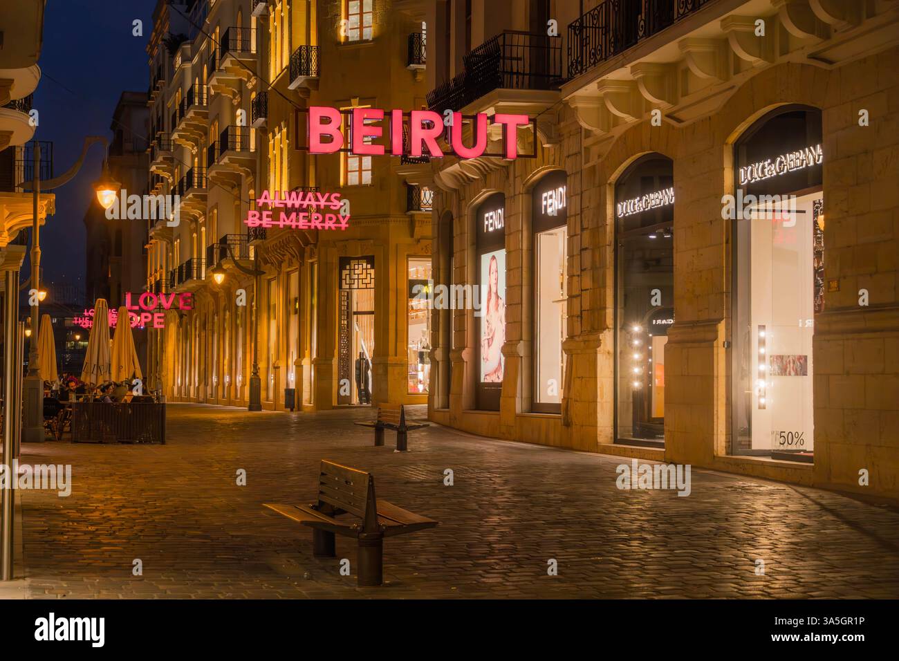 Via dello shopping di lusso nel centro di Beirut, Libano, che espone marchi di alta moda con insegne al neon illuminate che recano "BEIRUT", "ALWAYS BE MERRY" Foto Stock