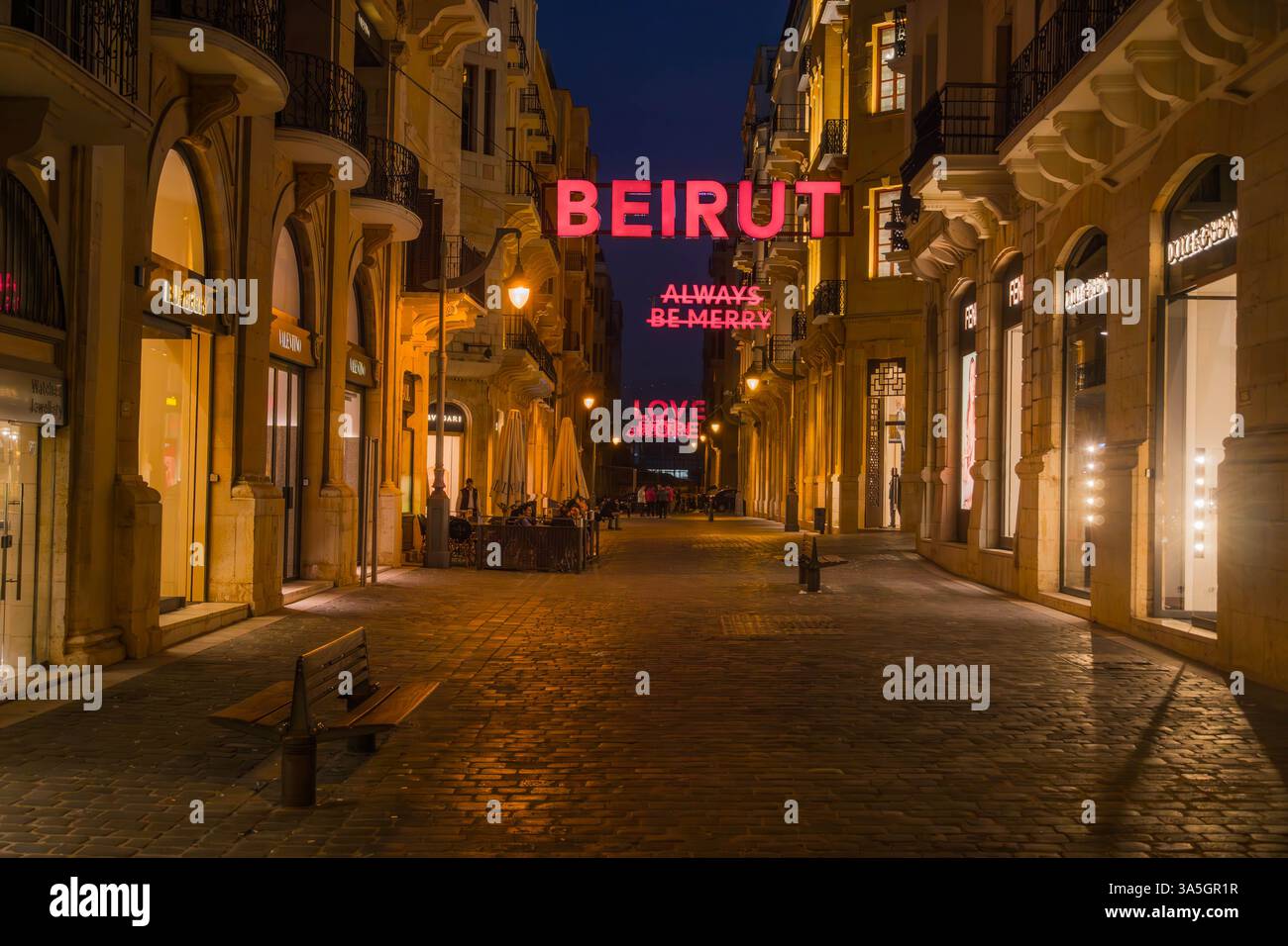 Via dello shopping di lusso nel centro di Beirut, Libano, che espone marchi di alta moda con insegne al neon illuminate che recano "BEIRUT", "ALWAYS BE MERRY" Foto Stock