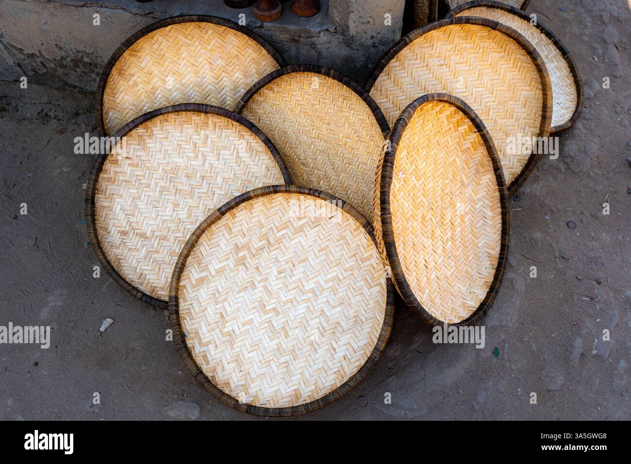 Vassoi di bambù intrecciati a mano impilati a terra - Tete, Mozambico Foto Stock
