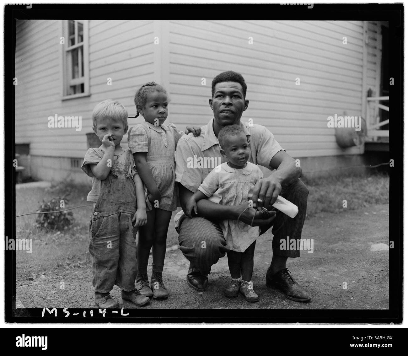Gonzalla Sullivan, un minatore, è raffigurato con i suoi due figli e un altro bambino dal quartiere di fronte alla loro casa vicino alla miniera federale n. 1 della Koppers Coal Division a Grant Town, West Virginia. Foto Stock