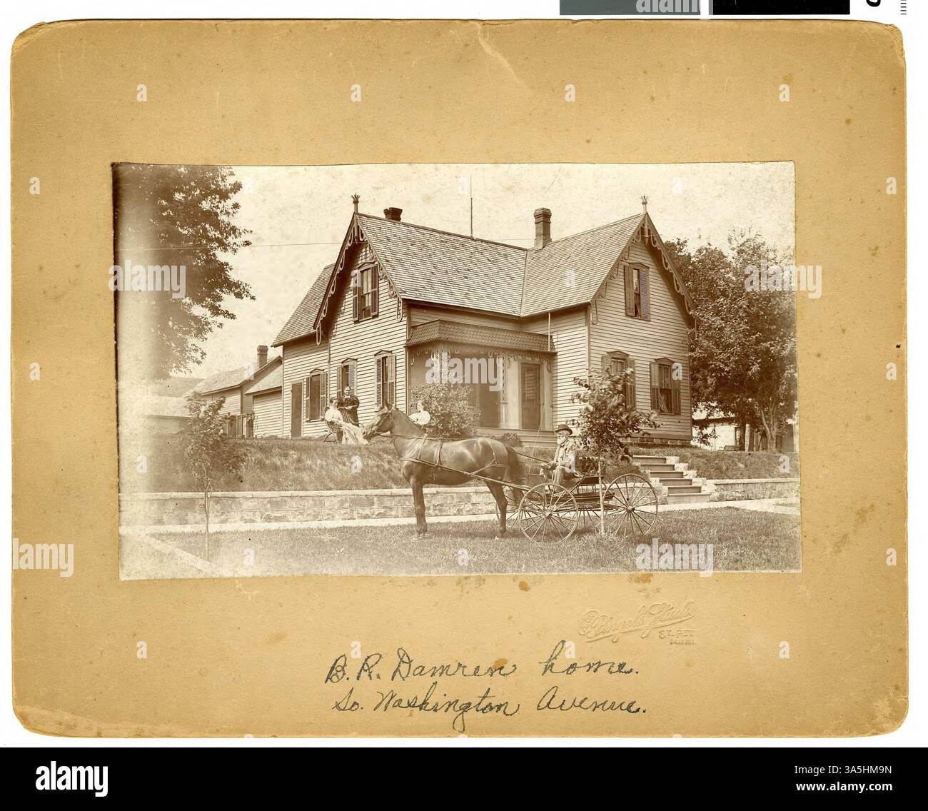 Questa fotografia mostra la casa di B. R. Damren, situata lungo South Washington Avenue a St. Peter, con un uomo in una carrozza trainata da cavalli in primo piano. Foto Stock