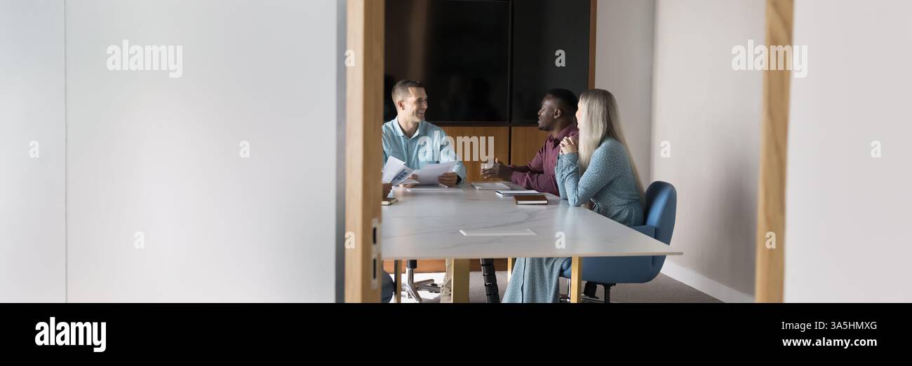 Uomini d'affari diversi, colleghi, azionisti riuniti nella sala conferenze, parlare al tavolo, condurre colloqui formali, collaborare, definire strategie, impegnato in Foto Stock