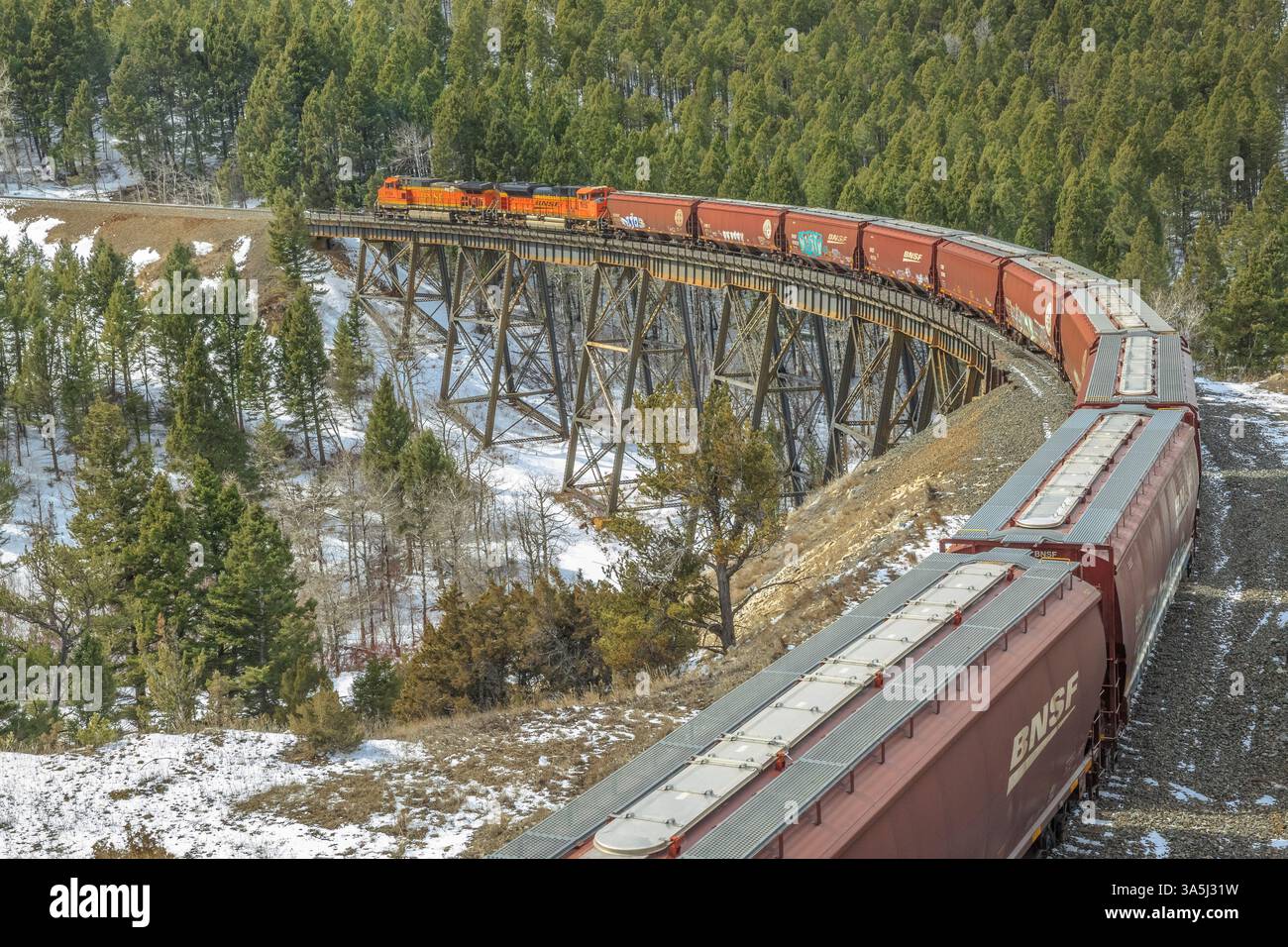 il treno diretto a mullan passa sopra un cavalletto vicino ad austin, montana Foto Stock