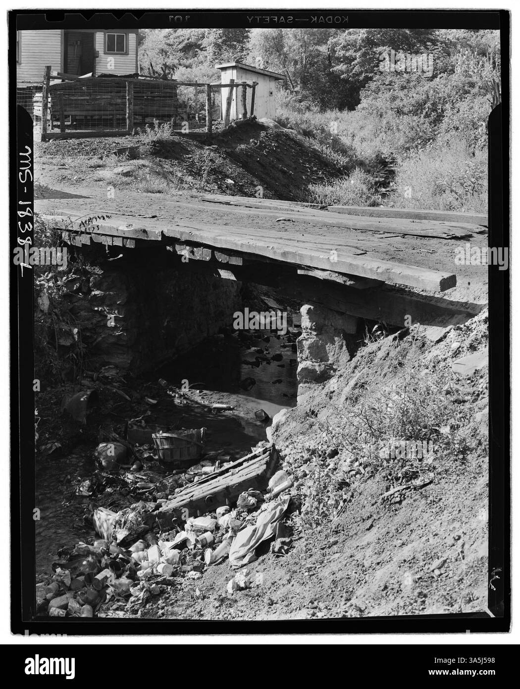 La fotografia mostra spazzatura e spazzatura lasciati lungo una riva del fiume presso Mullens Smokeless Coal Company di Mullens Mine ad Harmco, Wyoming County, West Virginia. Mette in evidenza le cattive condizioni sanitarie e la mancanza di gestione dei rifiuti nel campo minerario. Foto Stock
