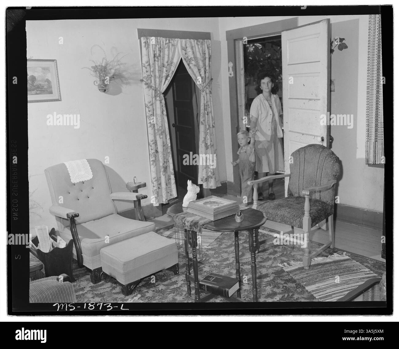 La signora Paul May, moglie di un minatore, e suo figlio entrano nella loro modesta casa di quattro stanze, parte della Jewell Ridge Coal Company Housing. L'affitto costa $12 al mese, con porte e finestre a schermo fornite dall'azienda. Archivi nazionali al College Park - Still Pictures. Foto Stock