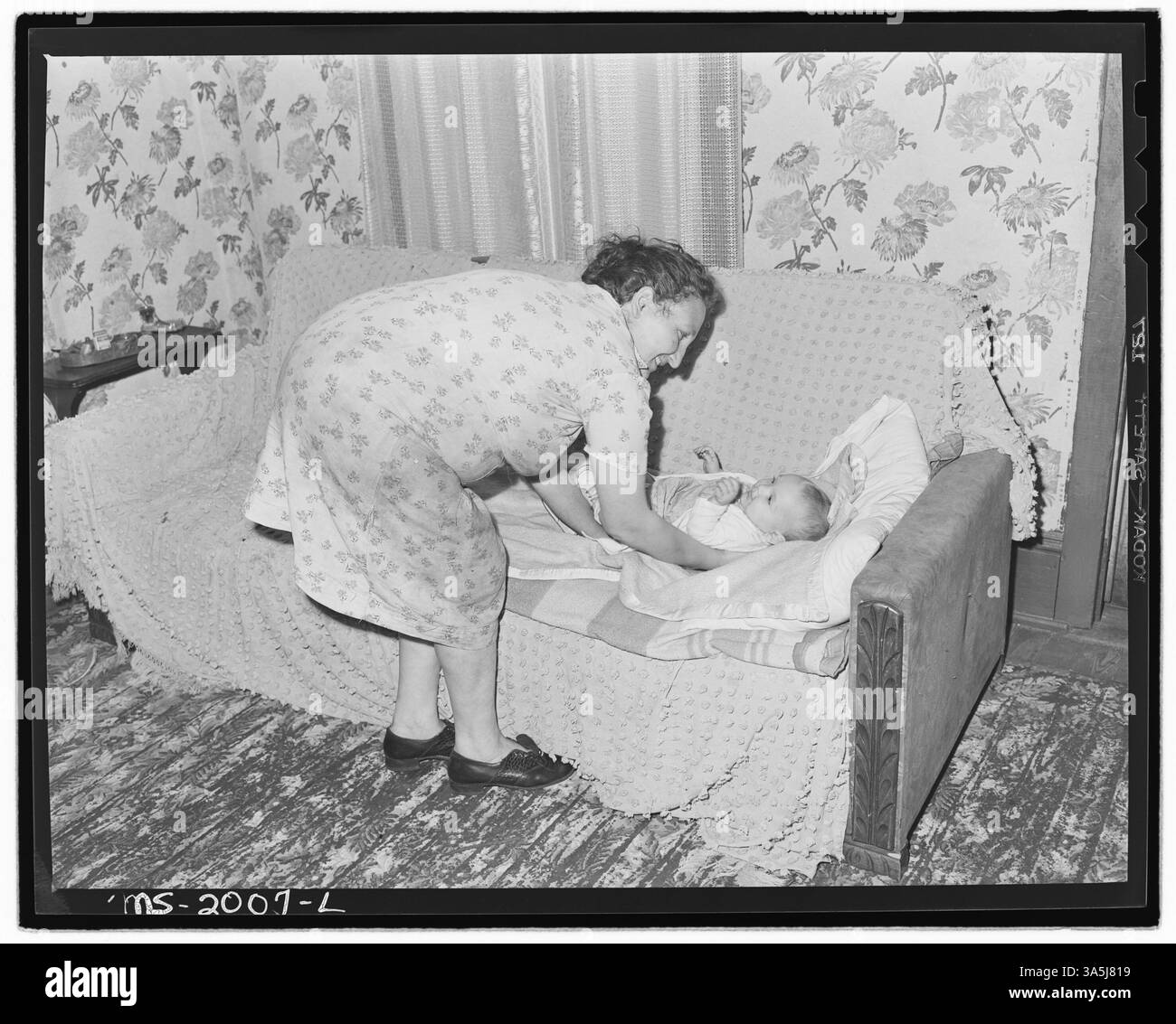 La signora Clabe Hicks, la moglie di un minatore, è vista con il suo bambino più giovane a Bradshaw, contea di McDowell, West Virginia, riflettendo la vita familiare della famiglia di un minatore di carbone. Foto Stock