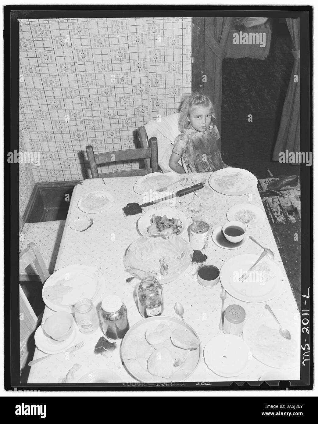 Figlia di Clabe Hicks, un minatore, nella casa di quattro stanze della Southern Coal Corporation, Bradshaw Mine, nella contea di McDowell, West Virginia. La famiglia Hicks di dieci persone vive in una casa con un tetto che perde, pagando 11 dollari di affitto mensile più costi aggiuntivi per le utenze. Archivi nazionali - Still Pictures. Foto Stock