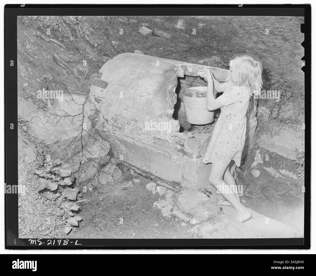 Figlio di un minatore che recupera acqua da una sorgente vicino alla miniera Big Jim Coal Company di Blanche, Bell County, Kentucky, con preoccupazione per la distanza e la pulizia dell'approvvigionamento idrico. Archivi nazionali - Still Pictures. Foto Stock
