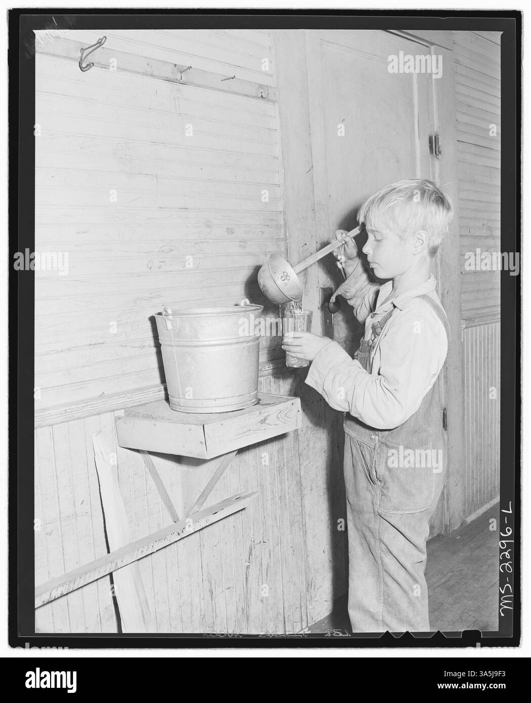 Il figlio di un minatore beve da un secchio aperto in una scuola di Four Mile, Bell County, Kentucky, in un'area colpita dall'esplosione della miniera Belva della Kentucky Straight Creek Coal Company nel 1945. Foto Stock