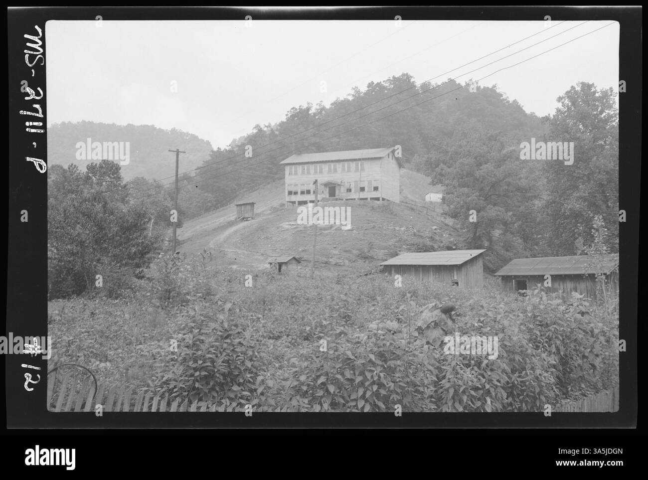 Una fotografia lontana di una scuola situata sulla cima di una collina a Premium, Letcher County, Kentucky, vicino a Premium Coals Inc Miniera Premium, con il bestiame autorizzato a vagare liberamente per il cortile. Foto Stock