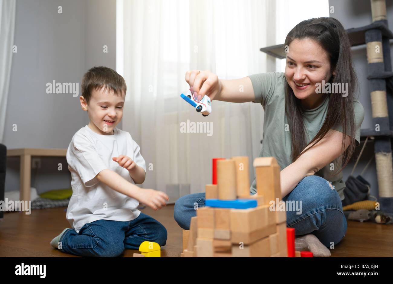 Il ragazzo gioca con i blocchi di legno con sua madre. Rafforzare i legami familiari sviluppando allo stesso tempo abilità motorie, logica e pensiero fantasioso. Squadra Foto Stock