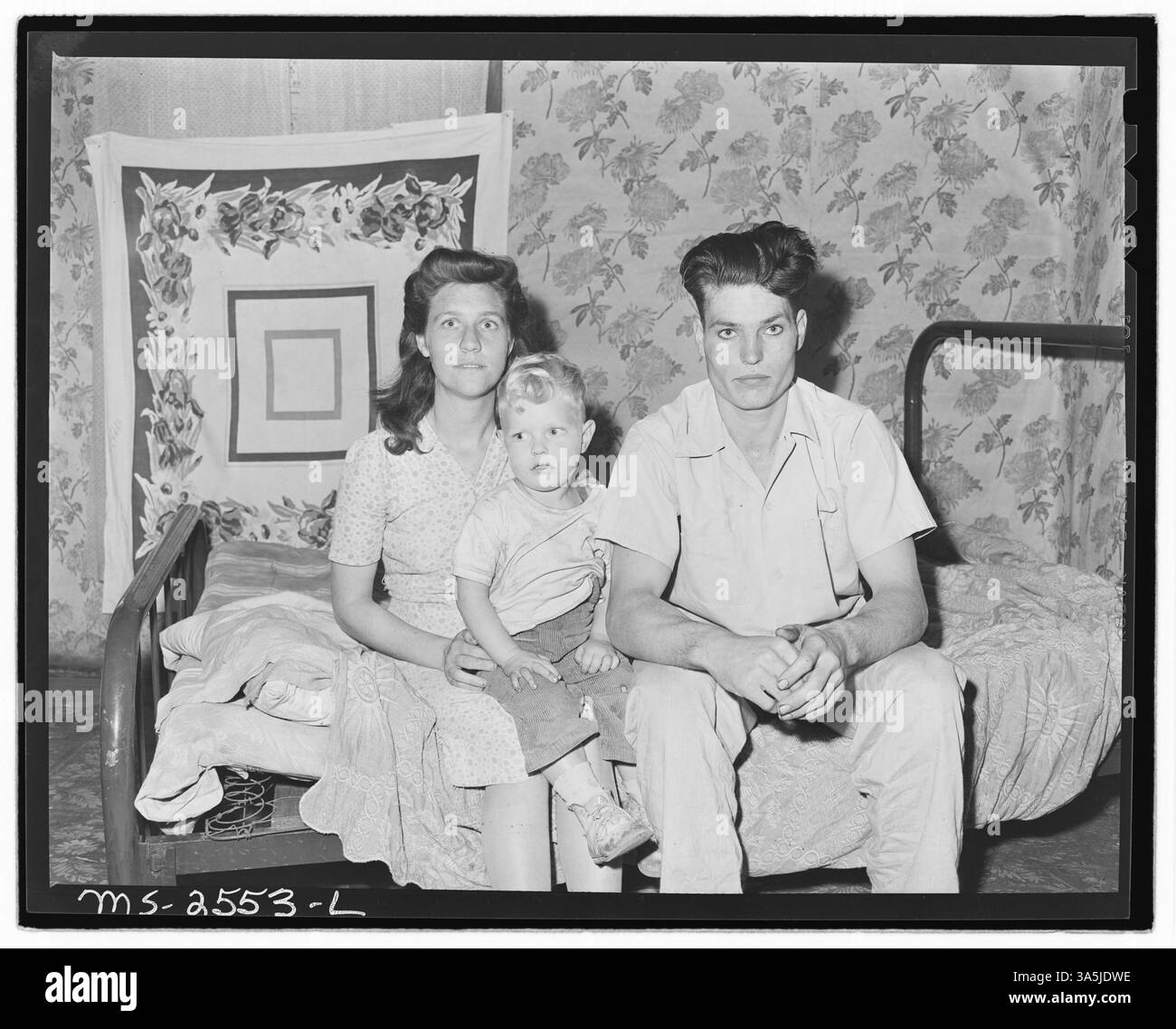 Rufus Sergent, 23 anni, lavora come cutter presso la miniera Clover Gap Mine di P V & K Coal Company a Lejunior, Kentucky. Figlio di Blaine Sergent, un minatore di carbone per 48 anni, Rufus iniziò a lavorare nelle miniere all'età di 15 anni. È raffigurato con sua moglie e suo figlio in questa fotografia dell'Archivio Nazionale. Foto Stock