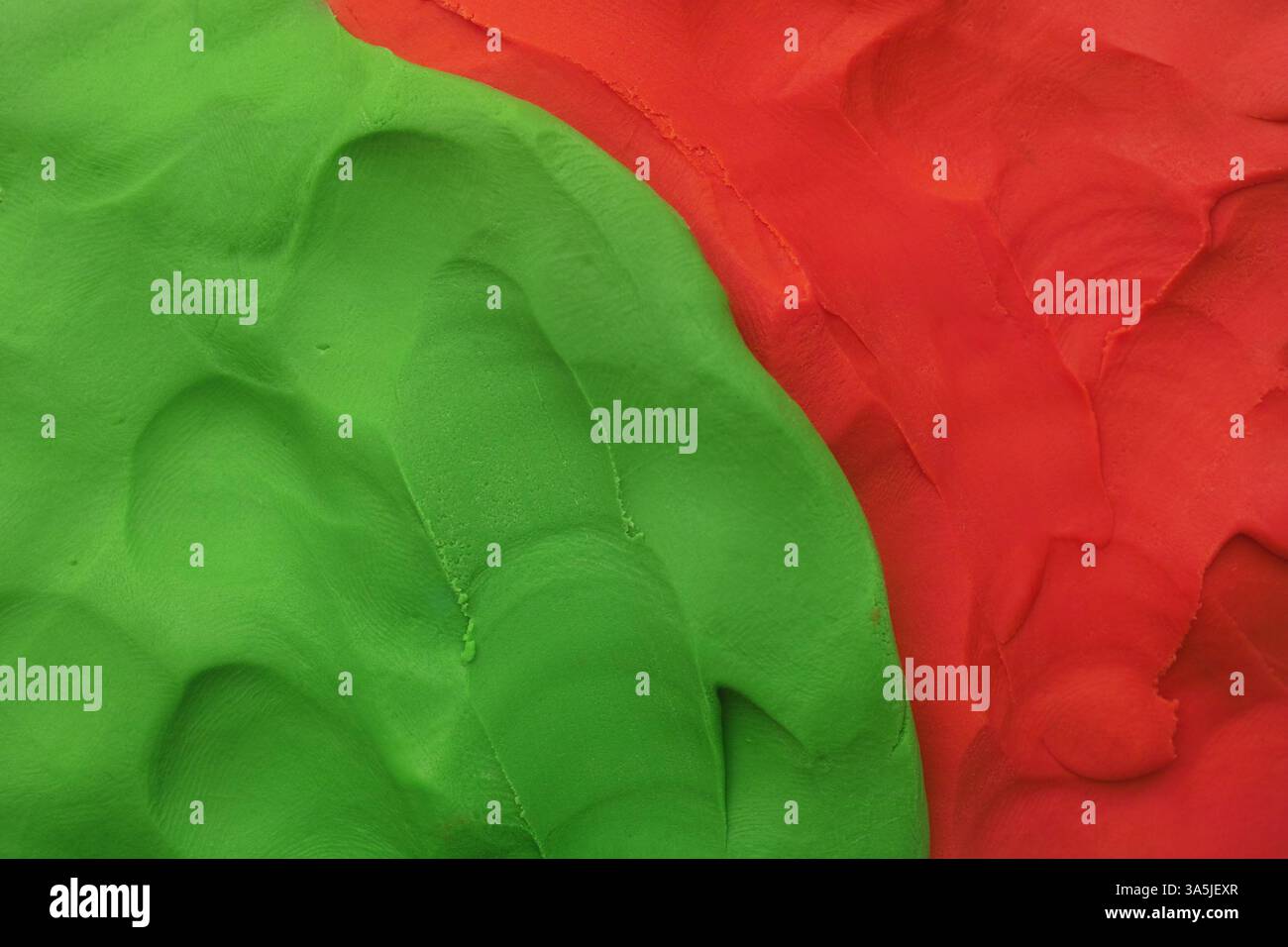 Una texture di sfondo fatta di argilla verde e rossa. Primo piano. Foto Stock