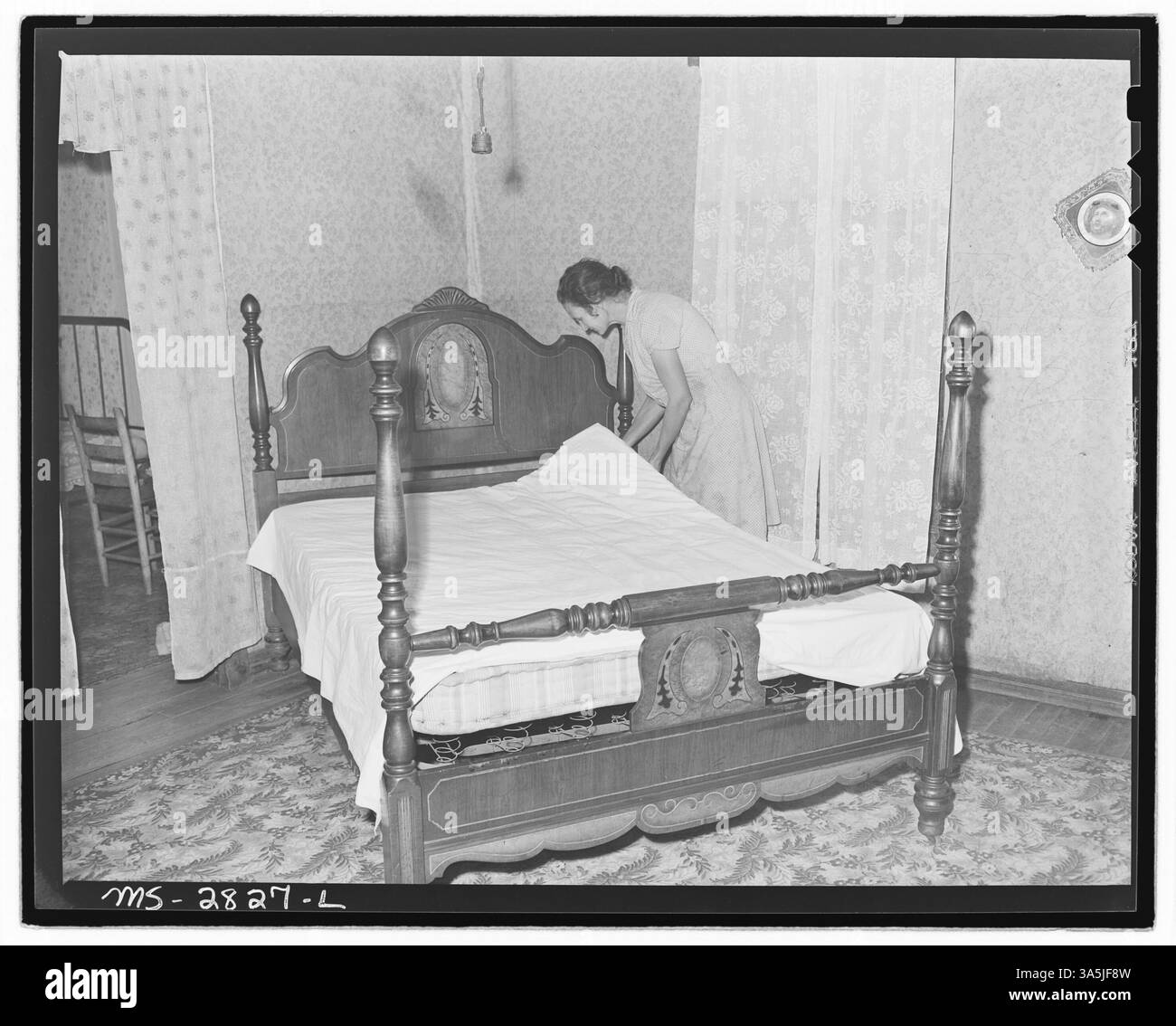 La signora Blaine Sergent, moglie di un caricatore di carbone alla miniera Clover Gap, fa il letto nella sua casa a Lejunior, nella contea di Harlan, Kentucky. Questa foto cattura un momento nella routine quotidiana della moglie di un minatore negli anni '1940 Foto Stock