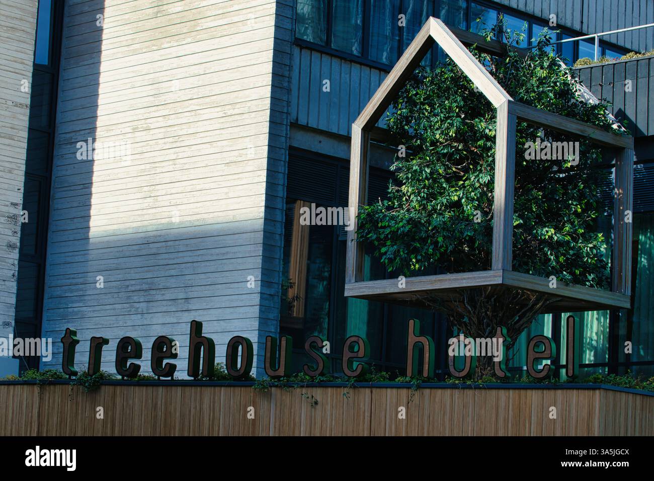 Esterno dell'edificio caratterizzato da un albero in una struttura a forma di casa, e le parole "Treehouse hotel" come insegna a Manchester, Regno Unito. Foto Stock