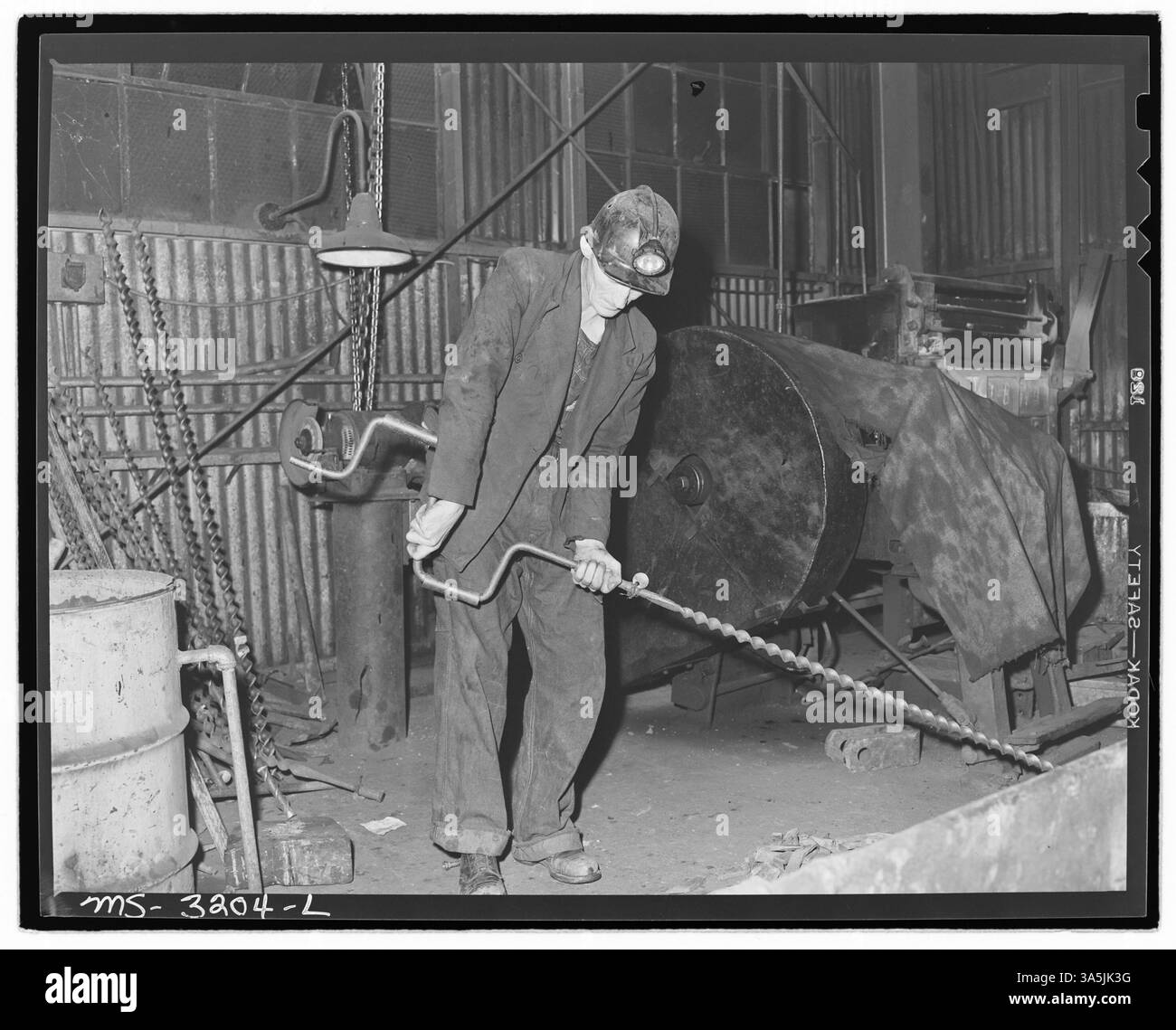 Harry Fain, una pala per carbone presso le miniere Wheelwright #1 e #2 della Inland Steel Company nella contea di Floyd, Kentucky, sta assemblando una coclea da utilizzare per la perforazione sulla superficie della miniera. Questa foto cattura le attrezzature minerarie in uso. Foto Stock
